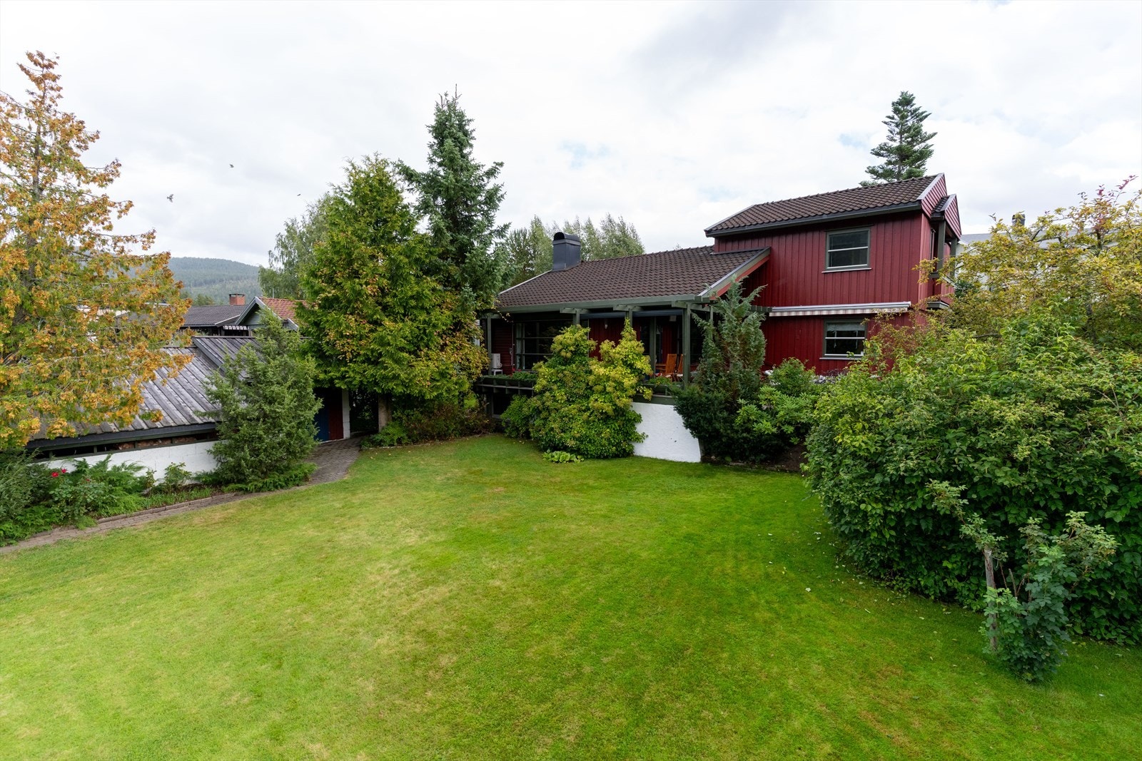 Fasadebildene med drone er tatt sensommeren 2025 med hagen i full blomst, i etterkant er taket byttet samt noe av kledningen. Galleribilde