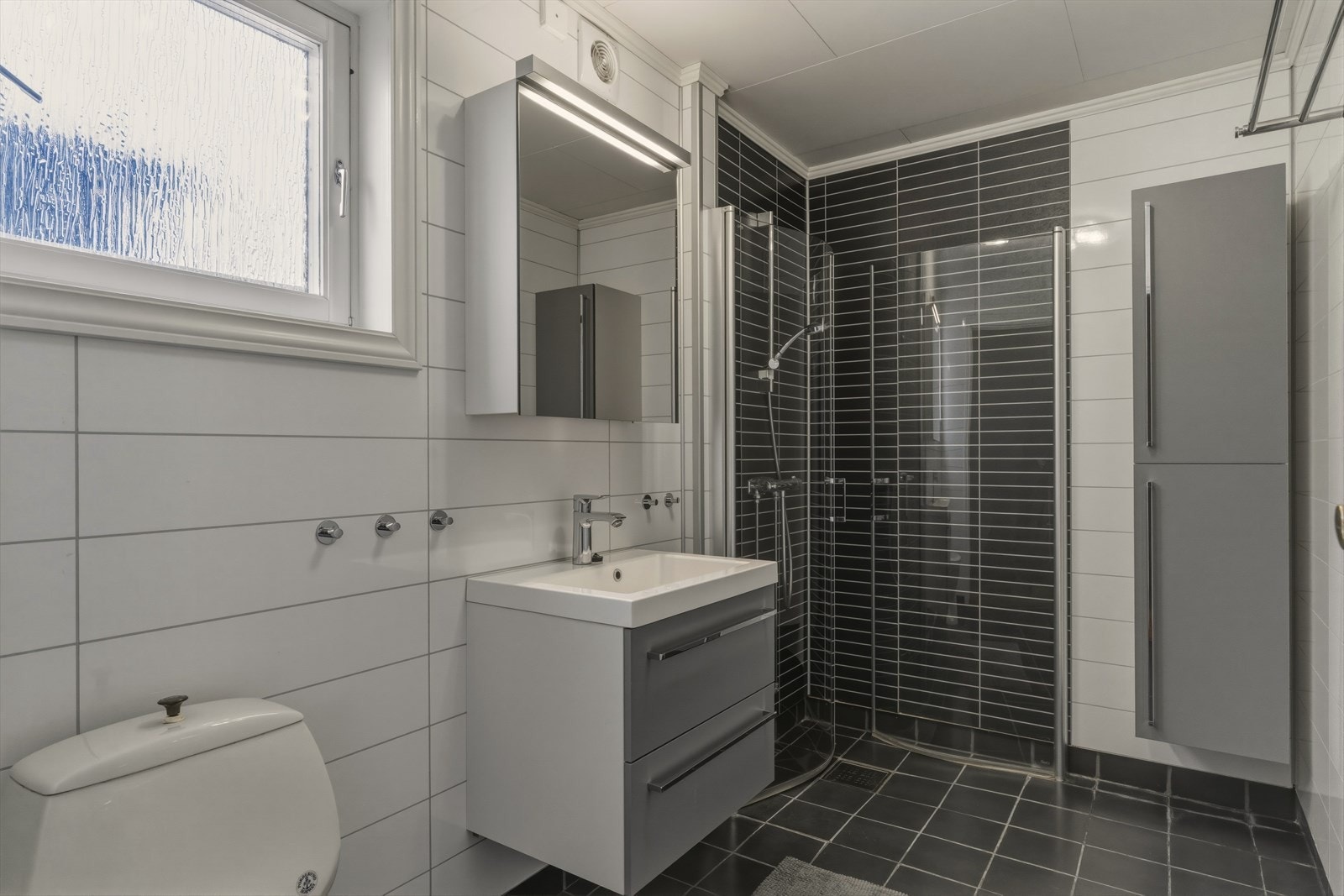 Bad 2. etasje innredet med pen servantinnredning, speilskap, toalett og dusjhjørne med dusjvegger. Varme i gulv. Galleribilde