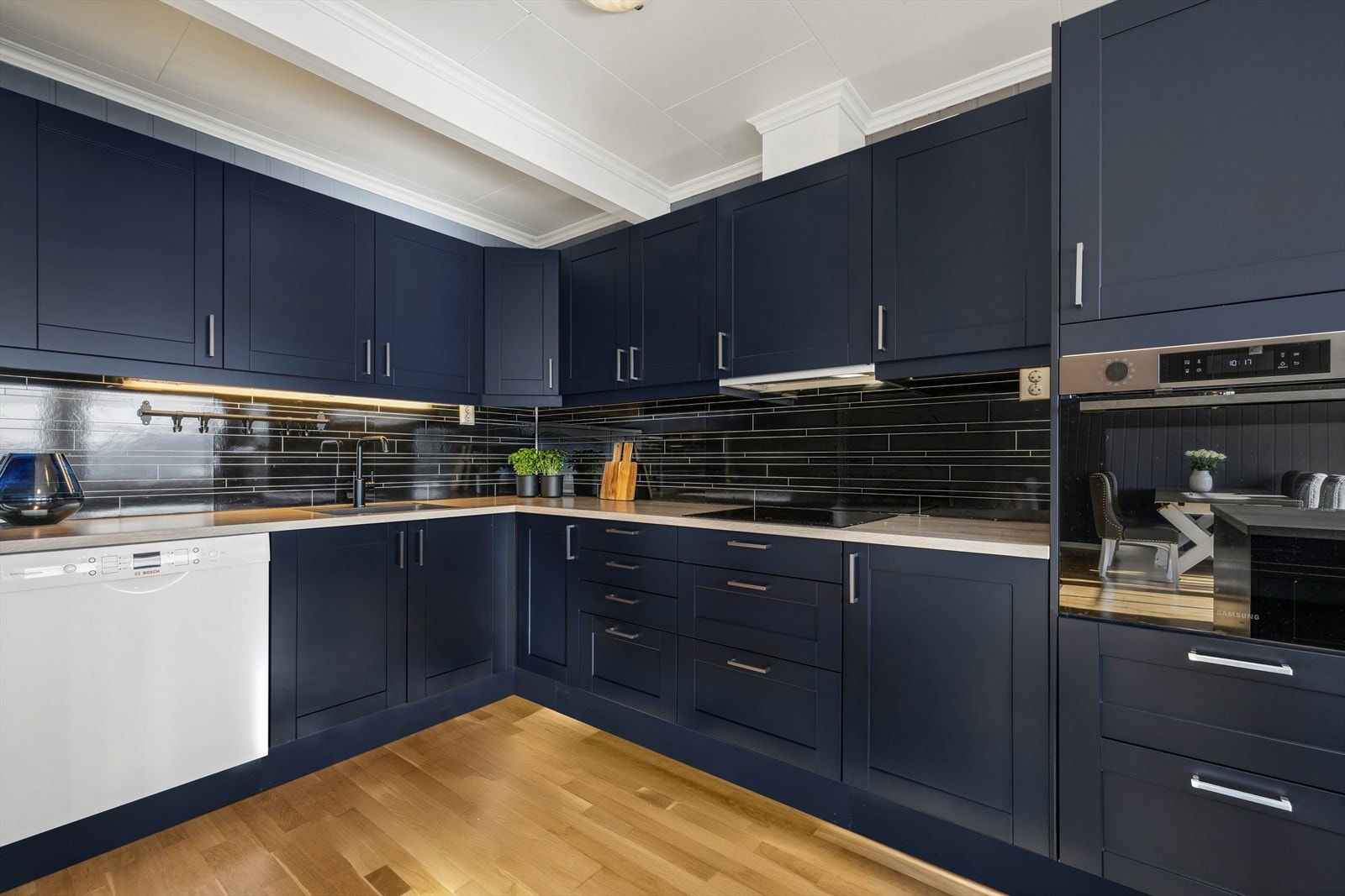 Kjøkkenet tilbyr gode kvaliteter som rikelig benke- og skapplass, hvitevarer, godt med overskap og plate på vegg mellom benkeplate. Galleribilde