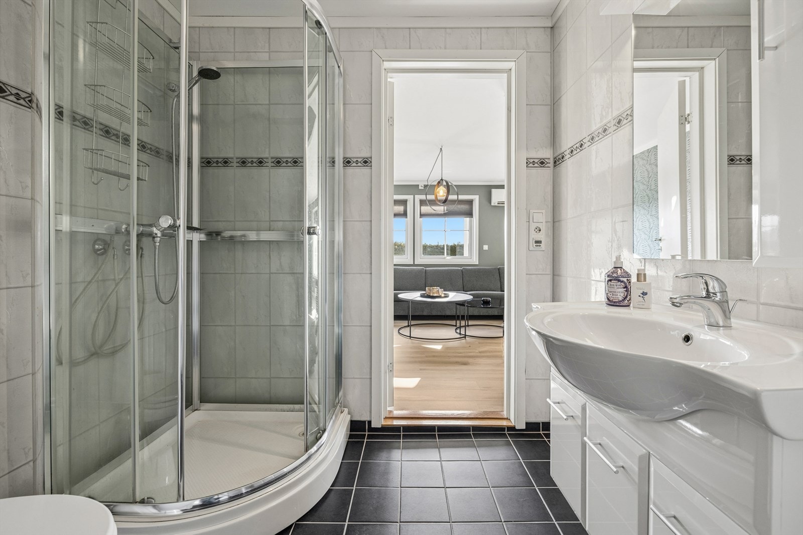 Rommet er innredet med servant med heldekkende servantplate, speil, toalett, dusjkabinett, skapinnredning og opplegg for vaskemaskin. Galleribilde