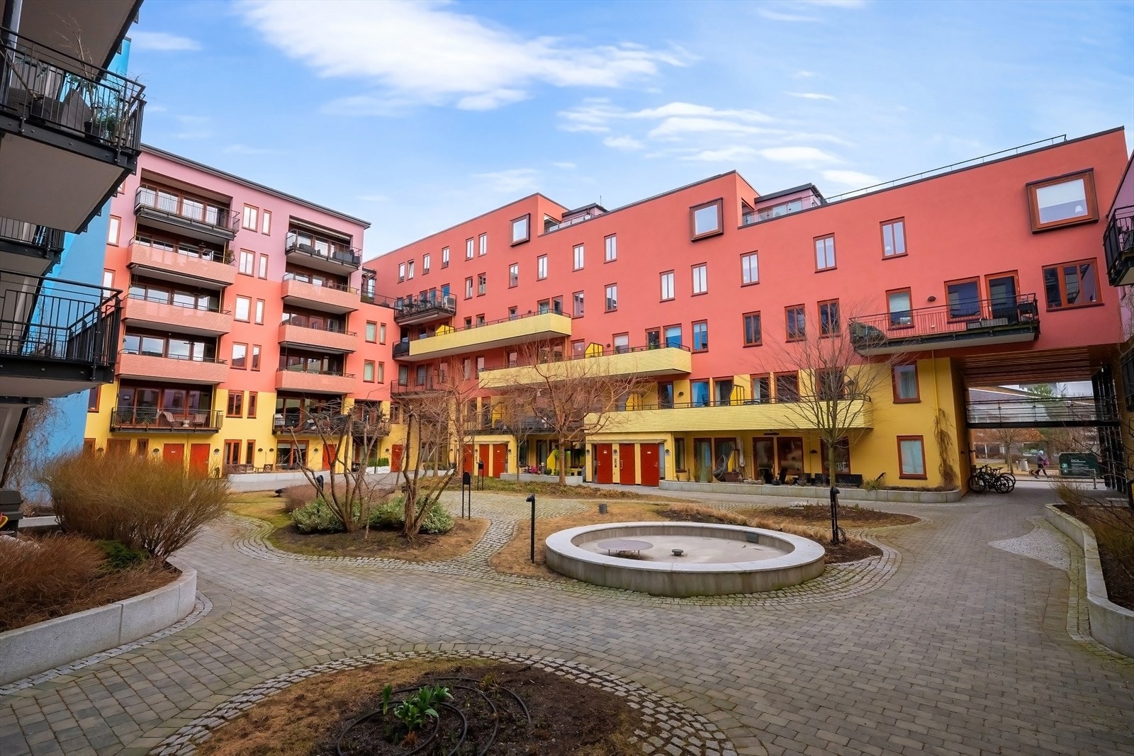 Hyggelig og pent opparbeidet gårdsrom med brostein, plen og beplantning. Galleribilde