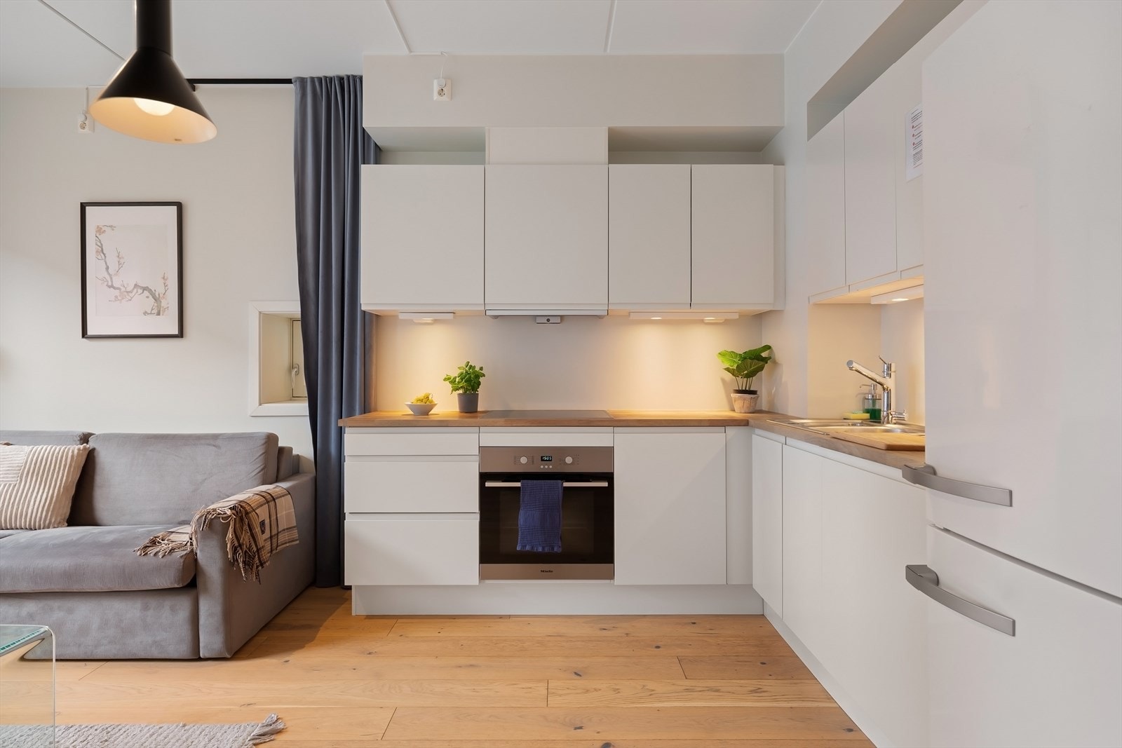 Det er integrert oppvaskmaskin, stekeovn og induksjonstopp samt frittstående kjøleskap. Galleribilde