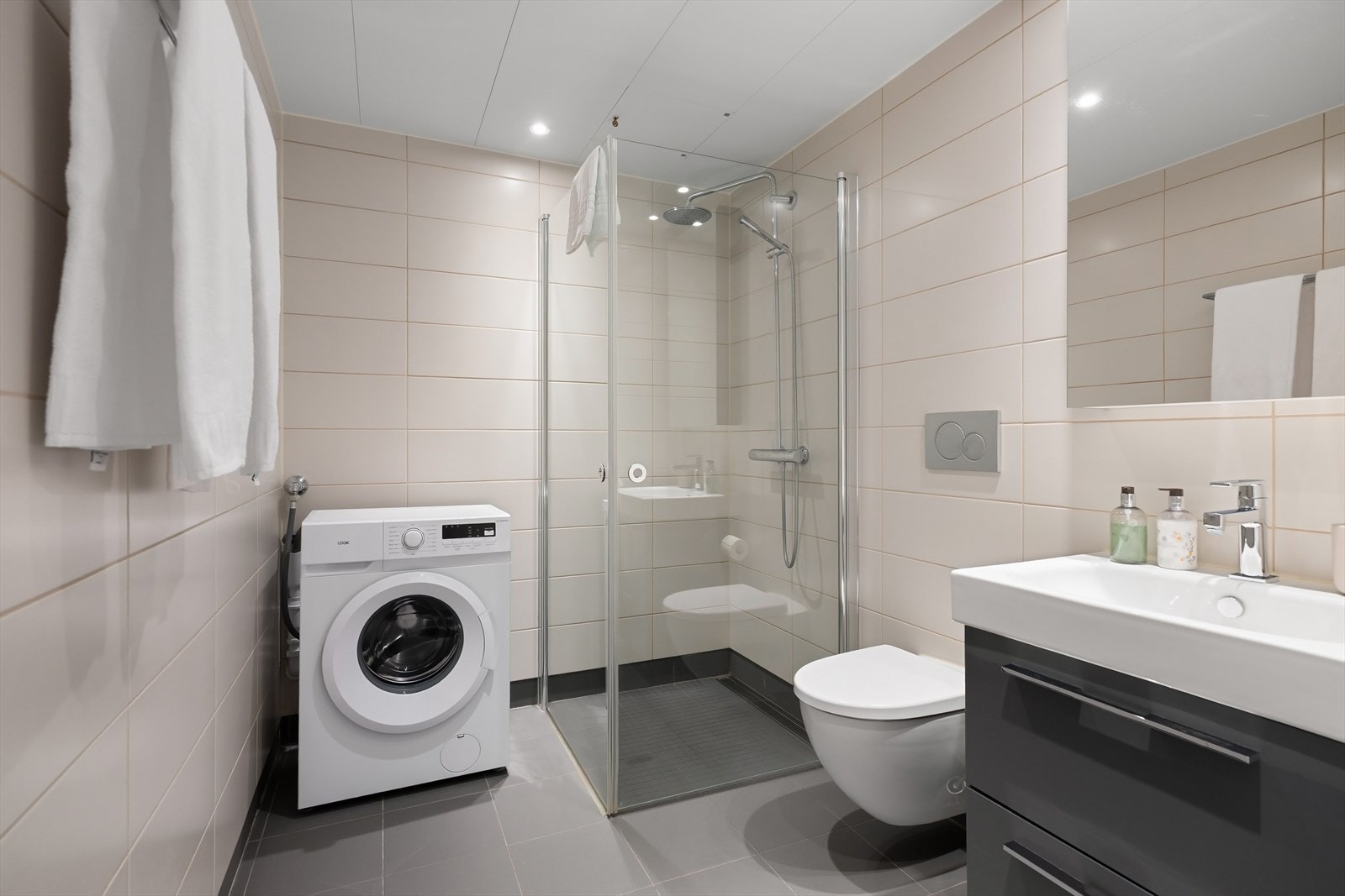 Flott bad fra 2016 av god størrelse. Badet har overflater med grå 30x30cm fliser på gulv med varme og 3x3cm mosaikkfliser i nedsenket dusjsone, lyse 20x50cm fliser på vegger og downlights i himling. Galleribilde