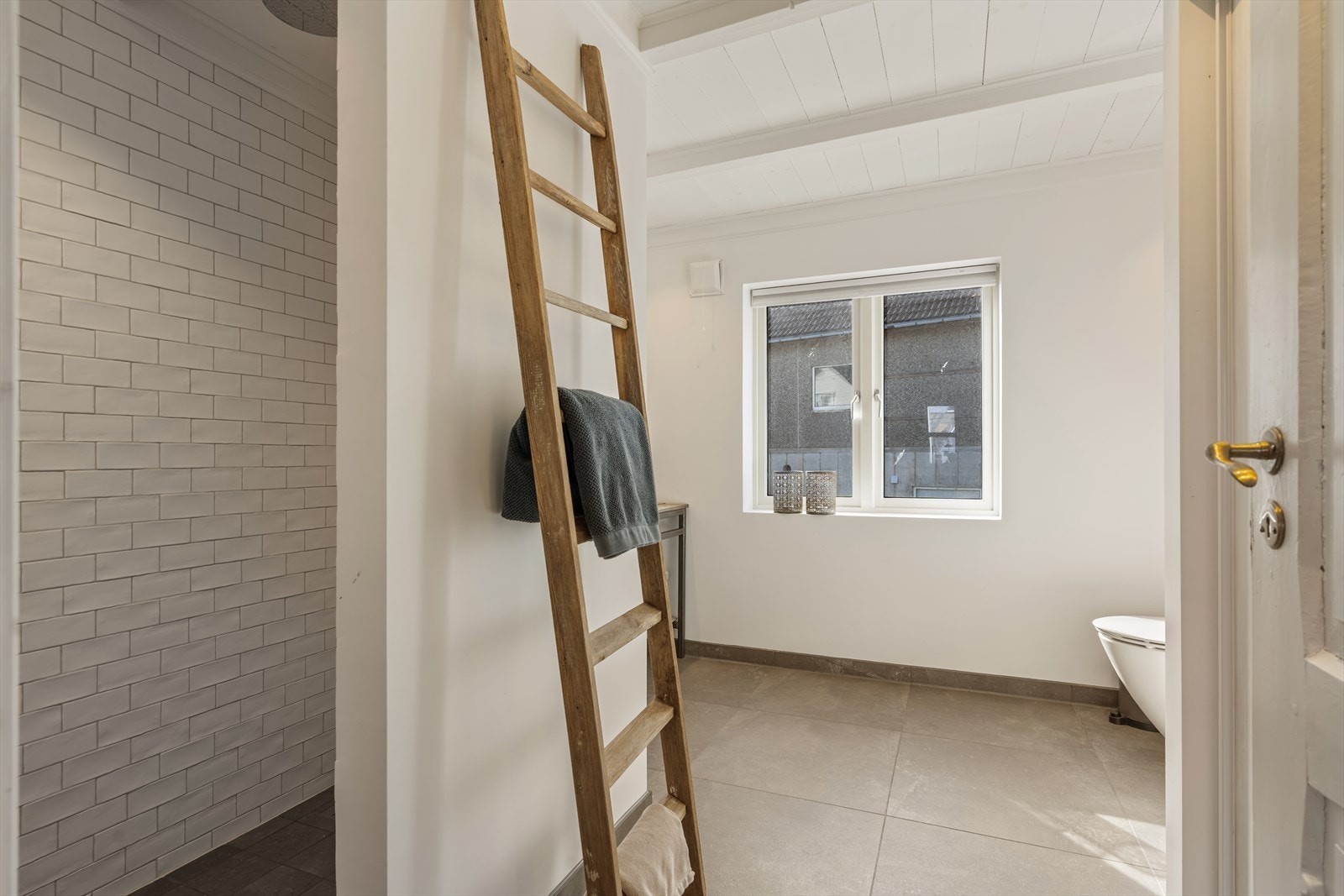 Lekkert og delikat baderom innredet med vegghengt wc, dusjhjørne, vask i selvbygget seksjon og opplegg for vaskemaskin. Galleribilde