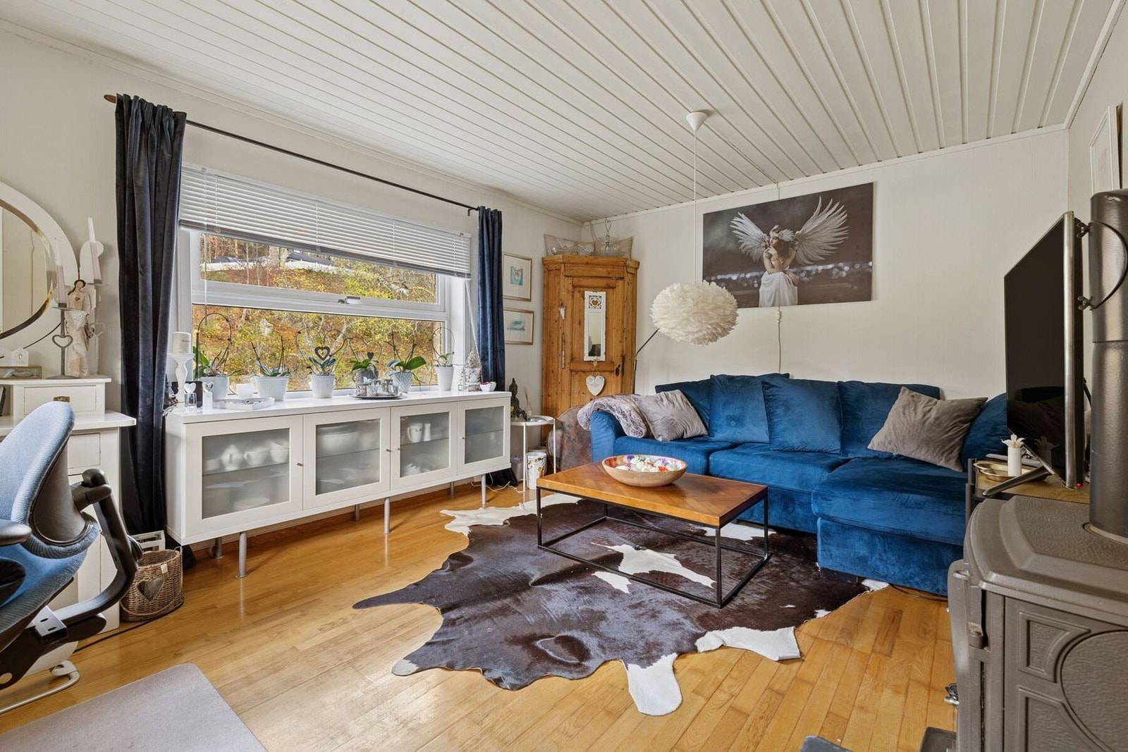 Stuen har god plass til sittegruppe. Her bidrar en vedovn til både varme og ekstra hygge, og skaper en stemningsfull atmosfære - særlig på kjøligere dager og kvelder. Galleribilde