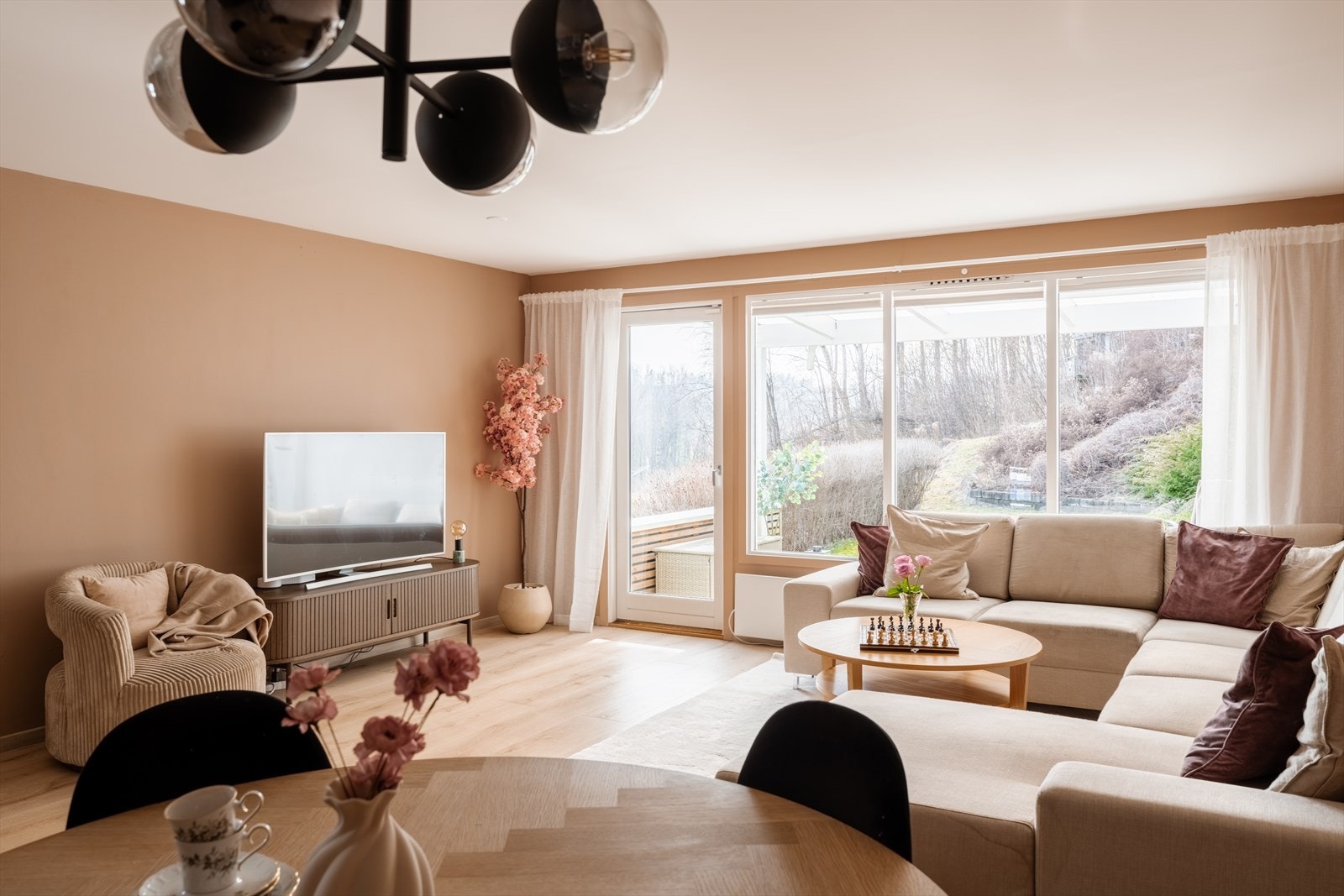 En lys og moderne stue med store vindusflater som fyller rommet med naturlig lys. Galleribilde