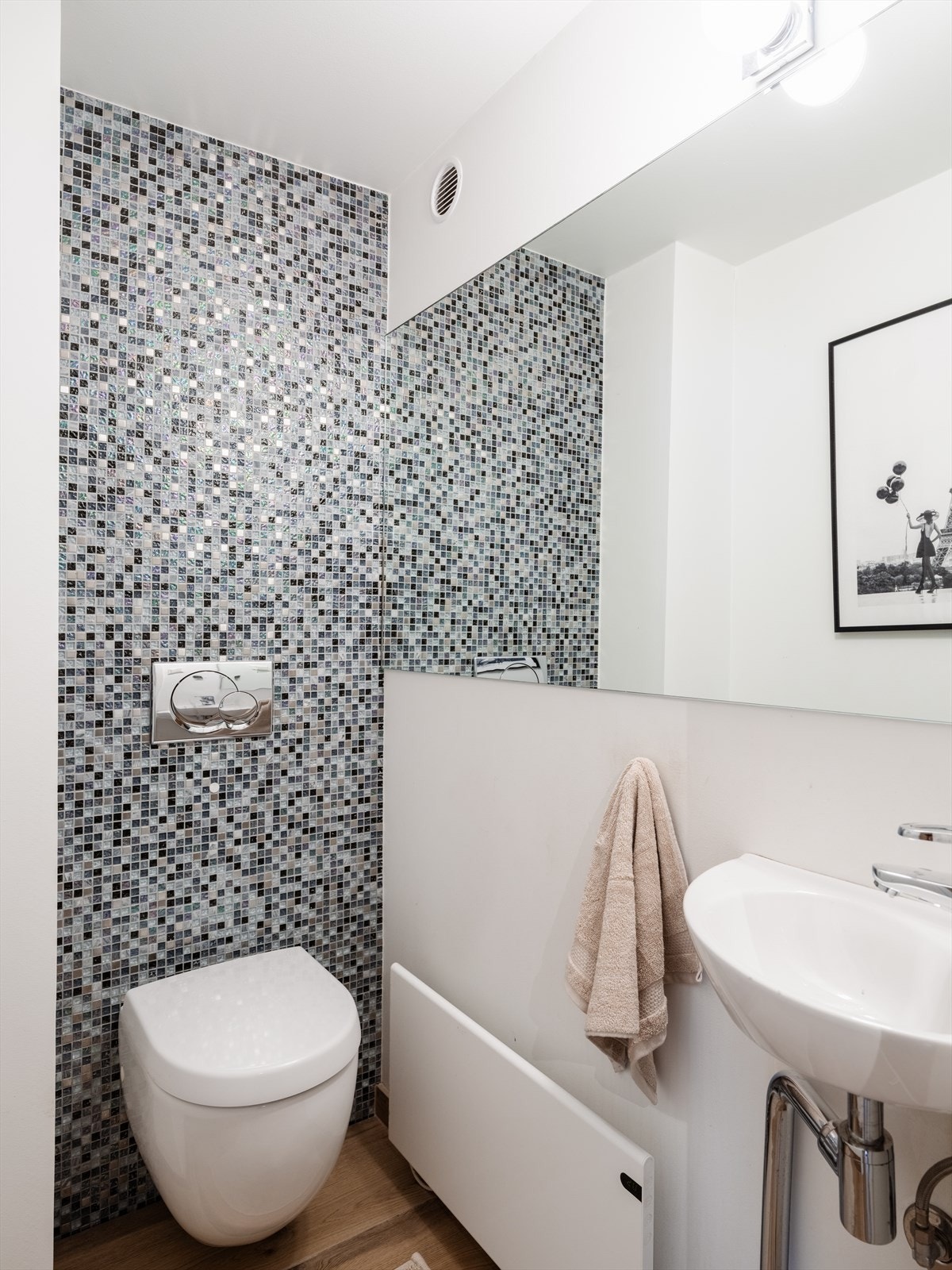 Rommet har et flislagt gulv og malte vegger og himling - mosaikkfliser i klosettvegg. Det er etablert vask, vegghengt klosett med innebygd sisterne. Galleribilde