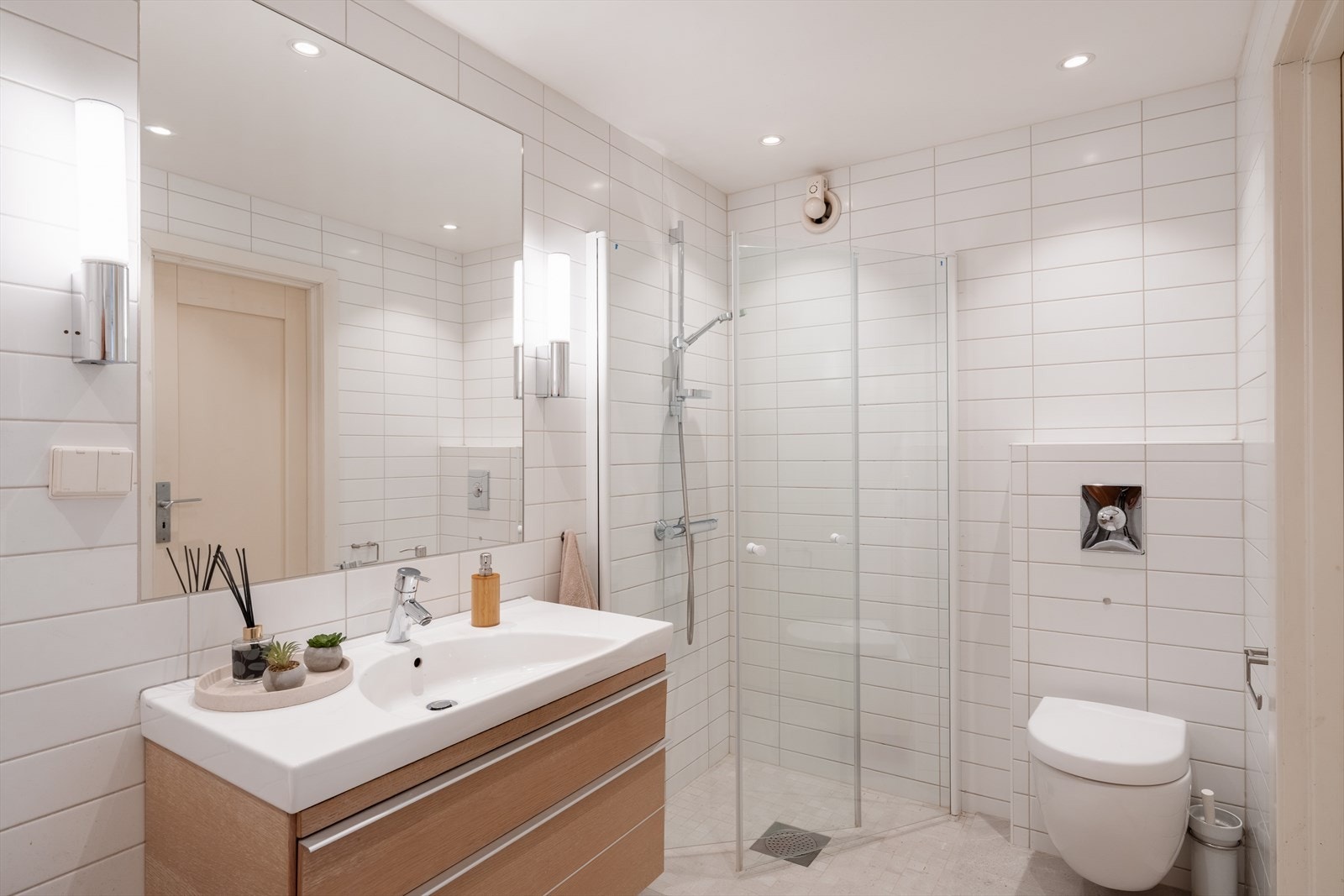 Badet har varmekabler i gulv og nedsenket himling med downlights. Galleribilde