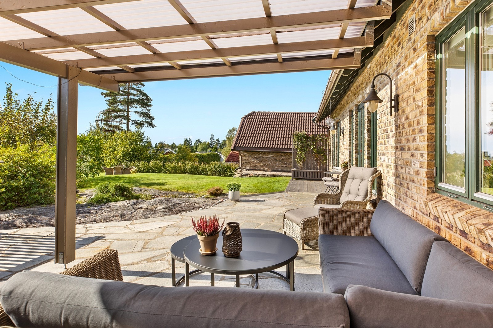 Fra uteplassen har man god oversikt over den grønne og frodige hagen. Galleribilde