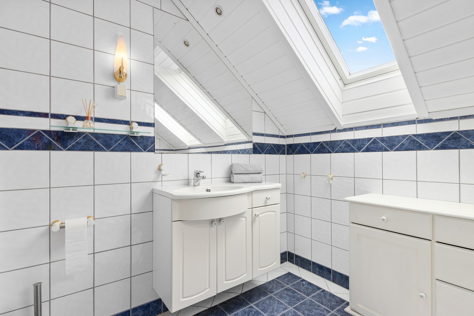 I 2. etasje/ loft har man et flislagt bad med skråtak. Badet har plass til oppbevaringsløsning. Galleribilde