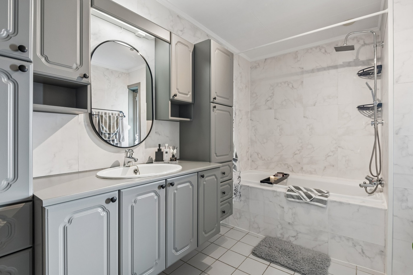 Bad i hovedetasje med badekar og flislagt gulv. Romslig baderomsinnredning. Galleribilde