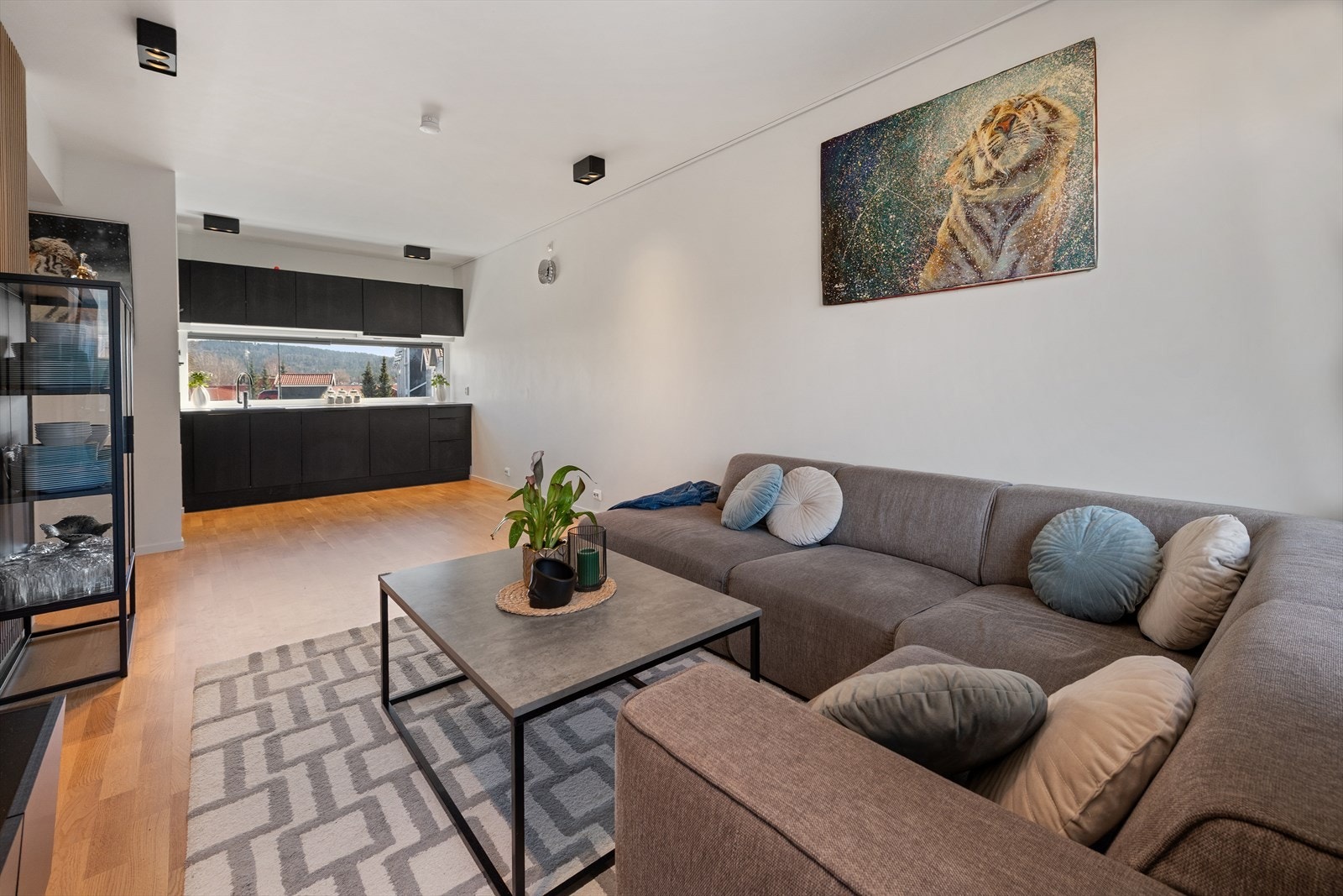 Stor stue som enkelt kan møbleres med spisebord ved kjøkkenet og stor sofa Galleribilde