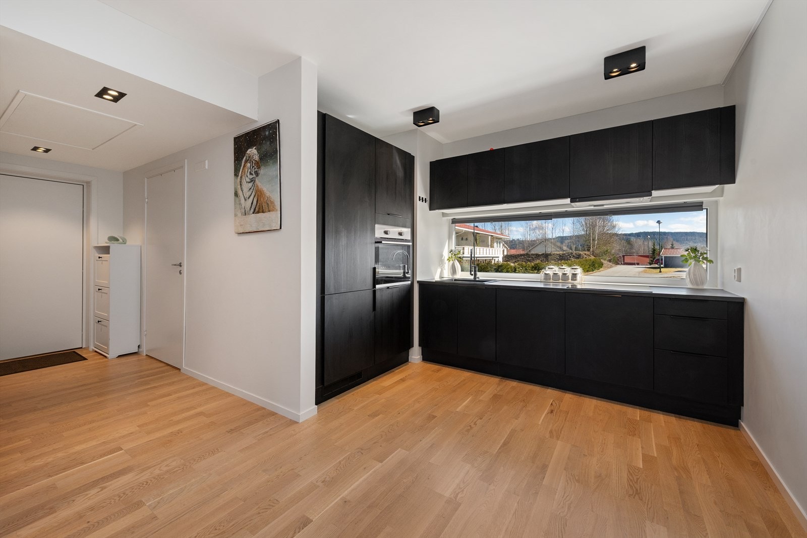 Kjøkken med integrerte hvitevarer. Vindu over benk gir gode naturlige lysforhold og fin utsikt Galleribilde