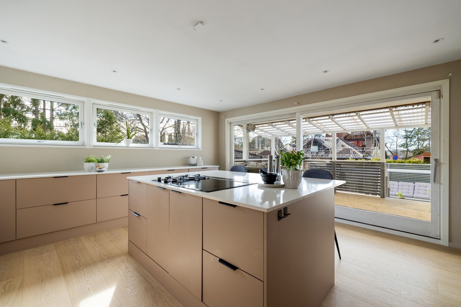 Fra kjøkkenet er det utgang til boligens terrasse, markterrasse og videre ned i hagen Galleribilde