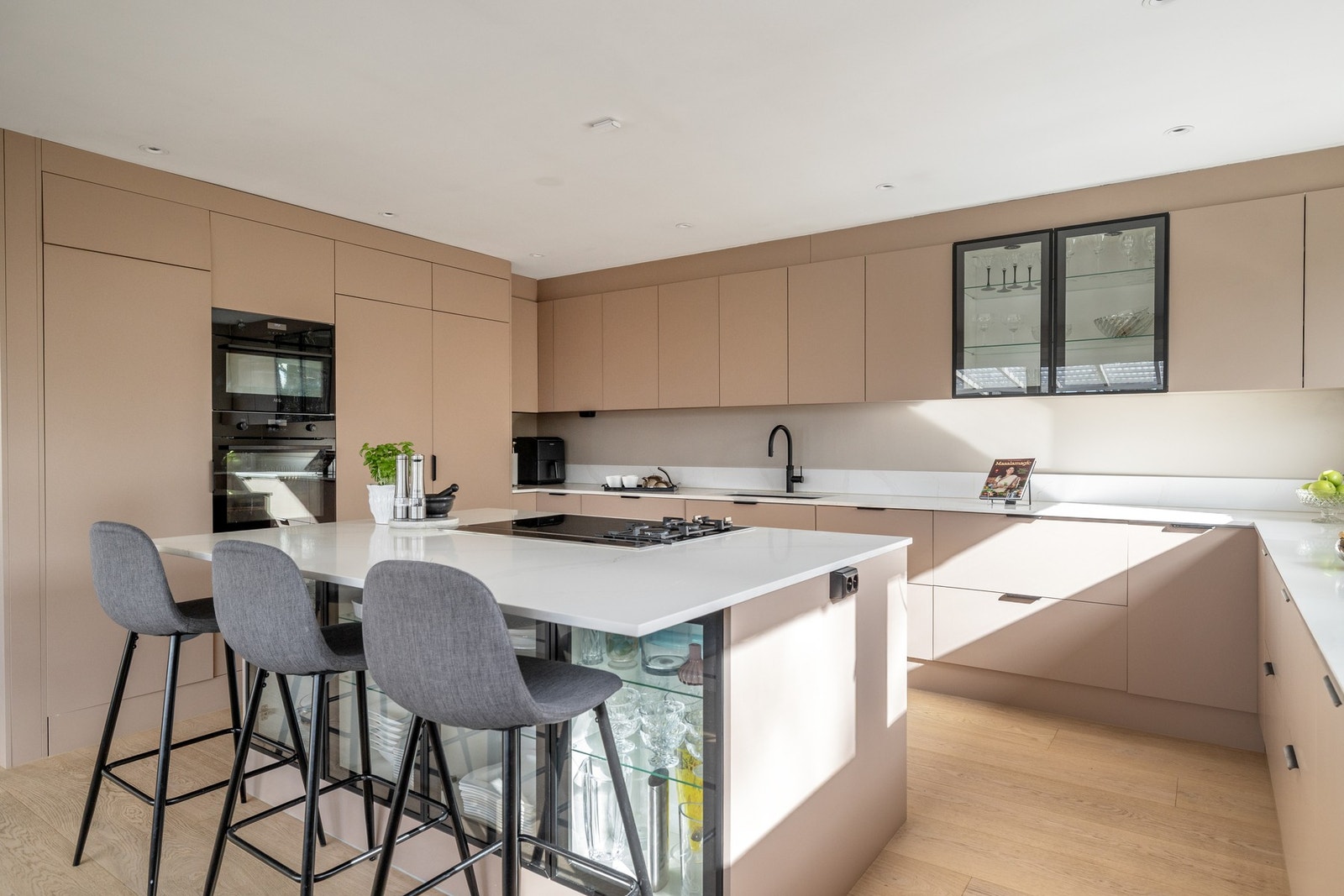 Kjøkkenet har en praktisk kjøkkenøy som både fungerer som et naturlig samlingspunkt, med plass til barkrakker på den ene siden og rikelig med oppbevaringsplass Galleribilde