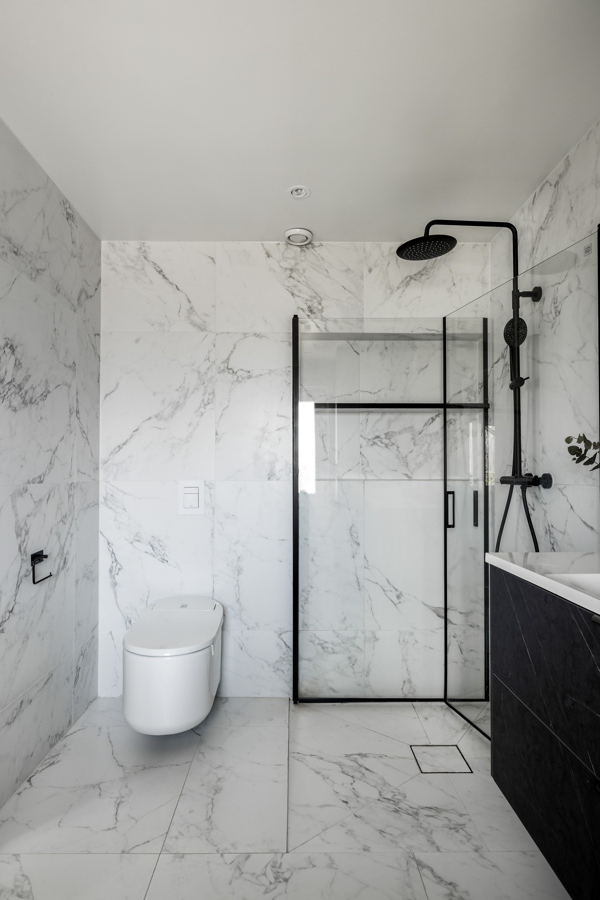 Innredningen består av servant over skuffeseksjon, praktisk høyskap, benk med lagring under, dushjørne og et moderne toalett med smarte funksjoner og automatisk spyling Galleribilde