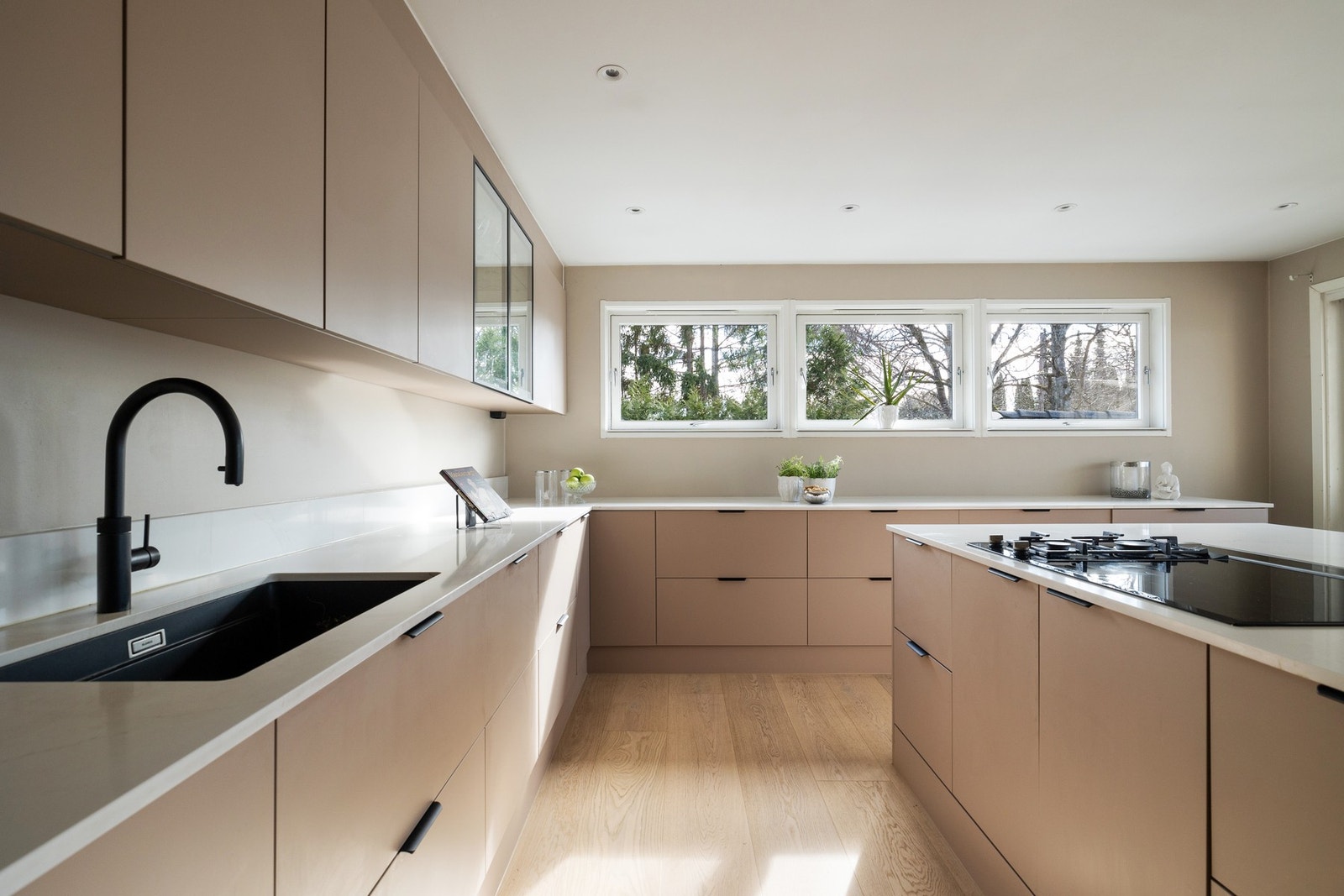 Kjøkkenet har innredning med glatte fronter. Lekker og eksklusiv benkeplate i ren kompositt med harmonisk design Galleribilde