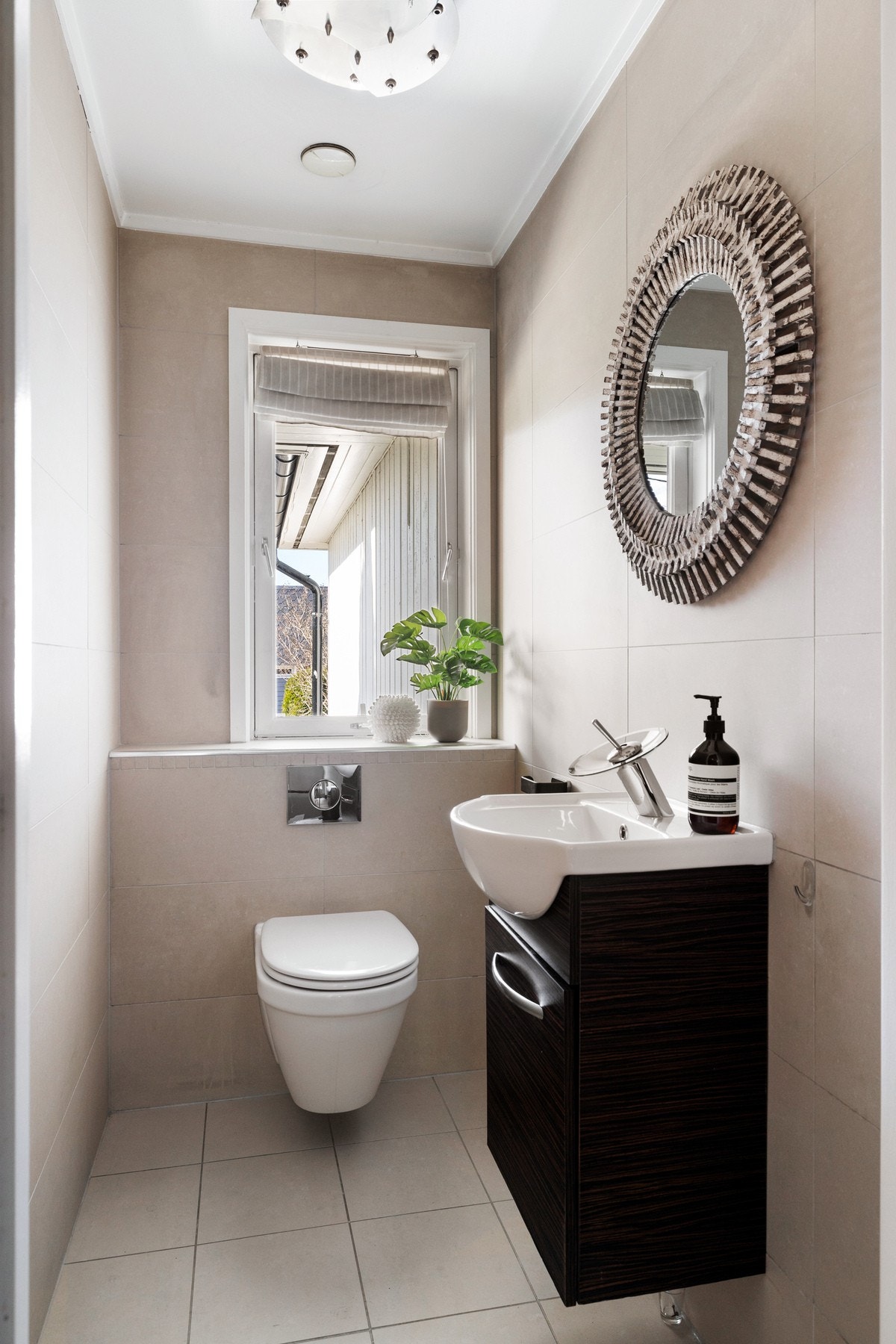 Fra hallen er det et stilrent og funksjonelt gjestetoalett som består av servant og veggheng toalett Galleribilde