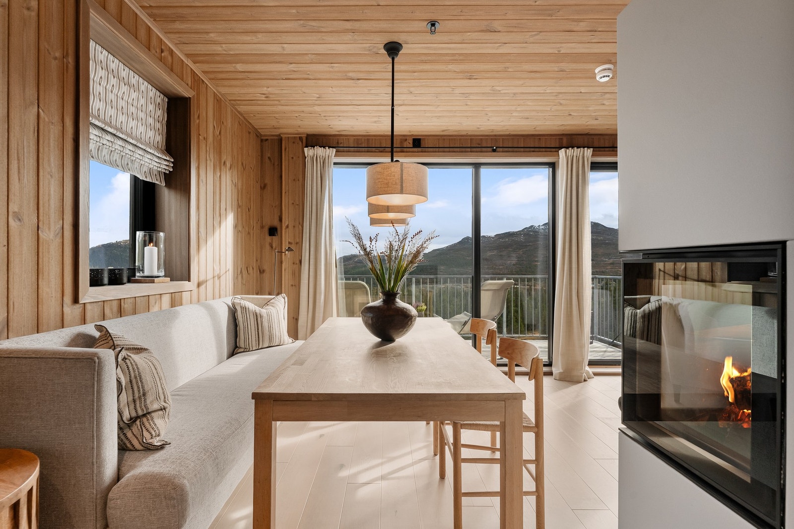 Her samles man rundt bordet med utsikt mot fjellheimen og peisens lune varme. Galleribilde