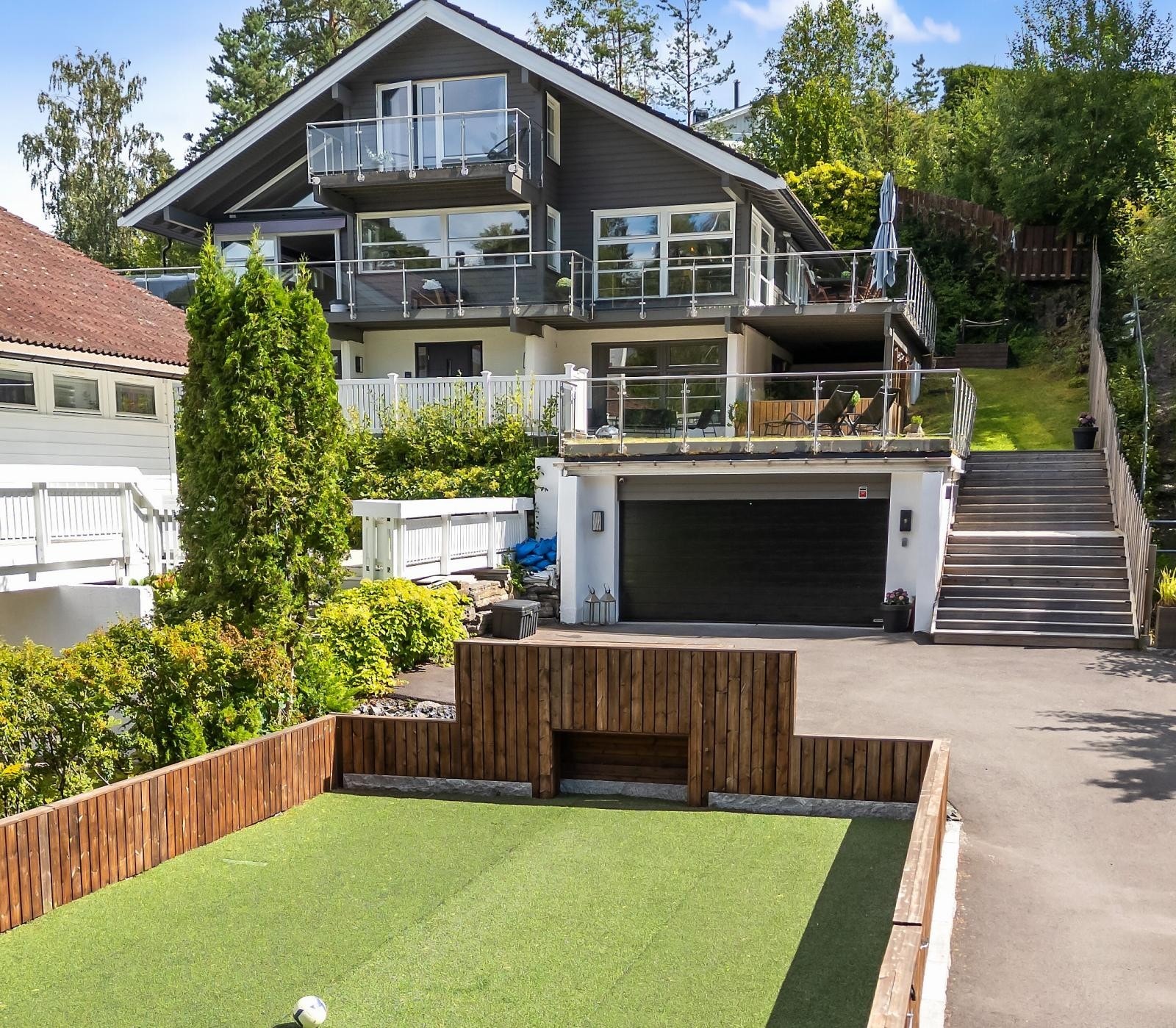 Huset ligger vestvendt og høyt i terrenget med fin utsikt over nærområdene. Dobbelgarasje i front med hage over garasjen, i tillegg er det etablert en privat ballbinge i forkant av boligen mot Storengveien. Galleribilde