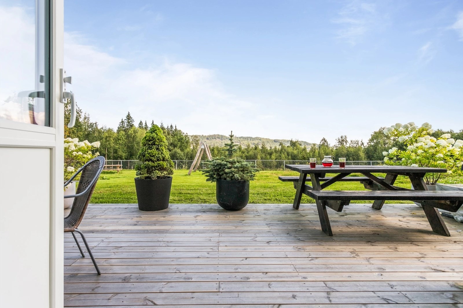 Stor platting foran huset med lekeplass rett nedenfor Galleribilde