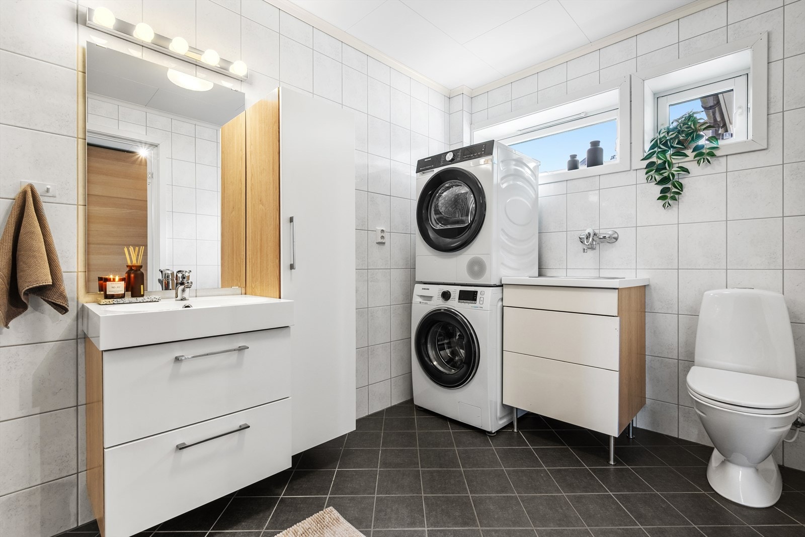 Badet er på 8 kvm, og har praktiske innfellbare dusjvegger, ekstra vask og opplegg for vaskemaskin - smart løsning som også gjør det til et kombinert bad/vaskerom. Galleribilde