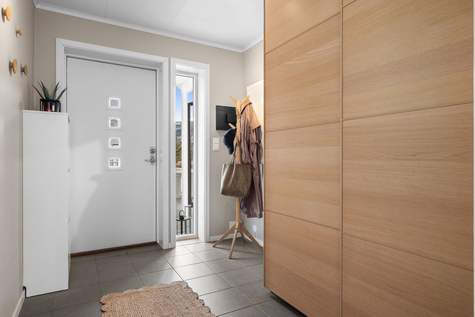 En innbydende entré ønsker deg velkommen inn i boligen. Entréen har en stor skyvedørsgarderobe for oppheng av klær og sko. Her får du flislagt gulv med varmekabler for ekstra komfort. Galleribilde