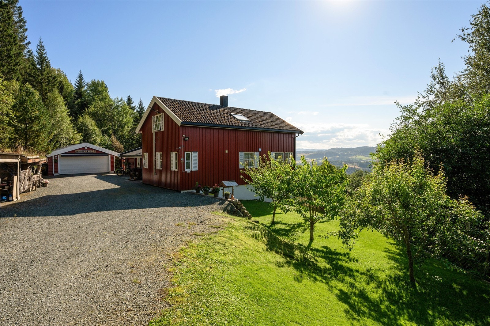 Solrik side av boligen med grønt og velstelt uteområde. Galleribilde