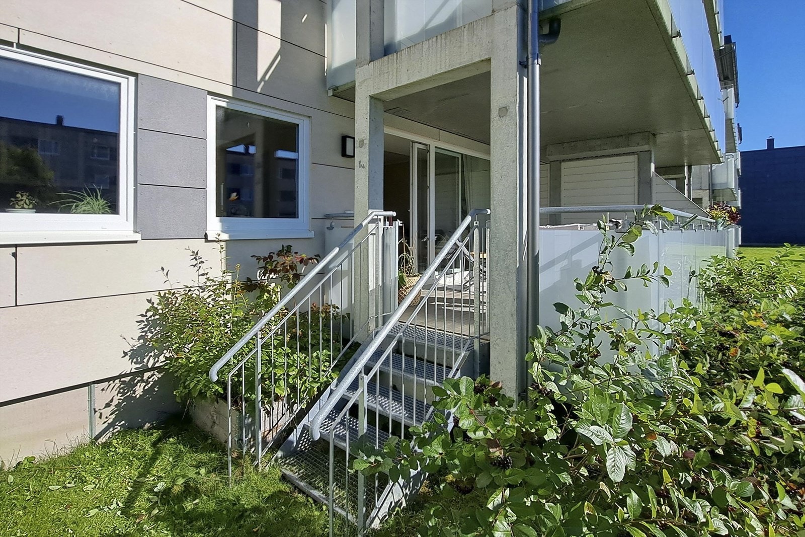 Eiers bilde. Direkte nedgang fra balkong til plena. Beplantning rundt balkong med bærbusker Galleribilde