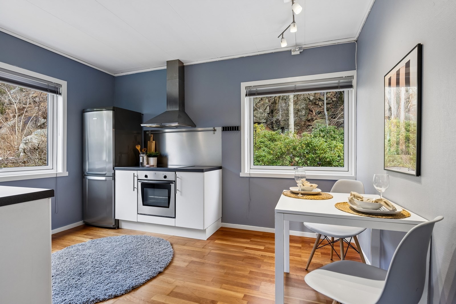 Funksjonelt kjøkken med spiseplass ved vindu Galleribilde