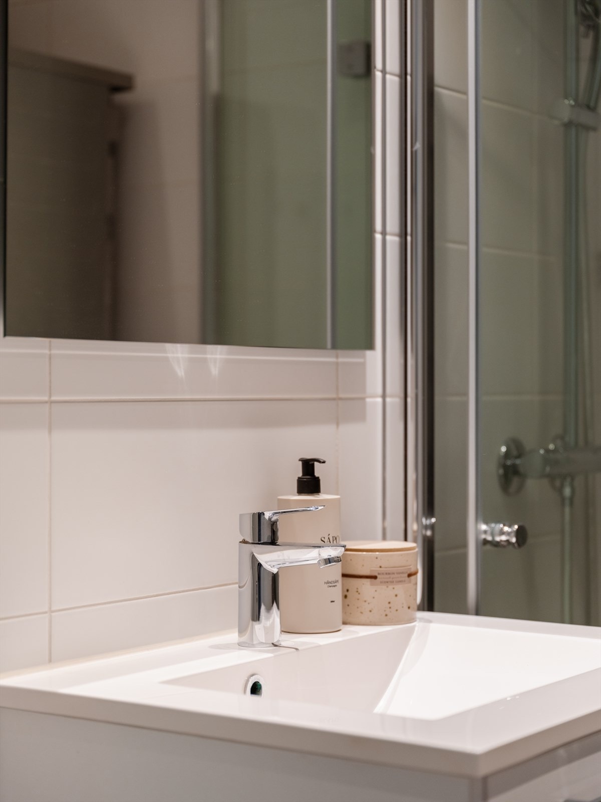 Badet har stilren baderomsinnredning med heldekkende servant og oppbevaringsplass. Galleribilde