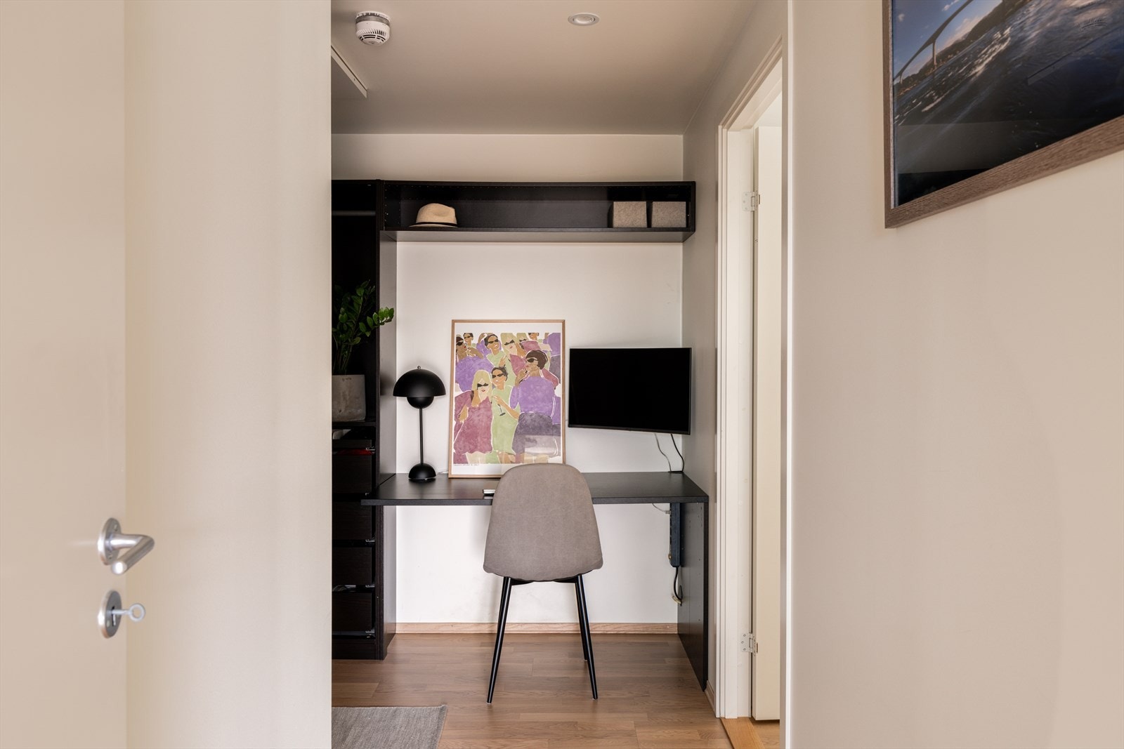 Den plassbygde garderobeløsningen i gangen inkluderer en funksjonell kontorplass. Galleribilde