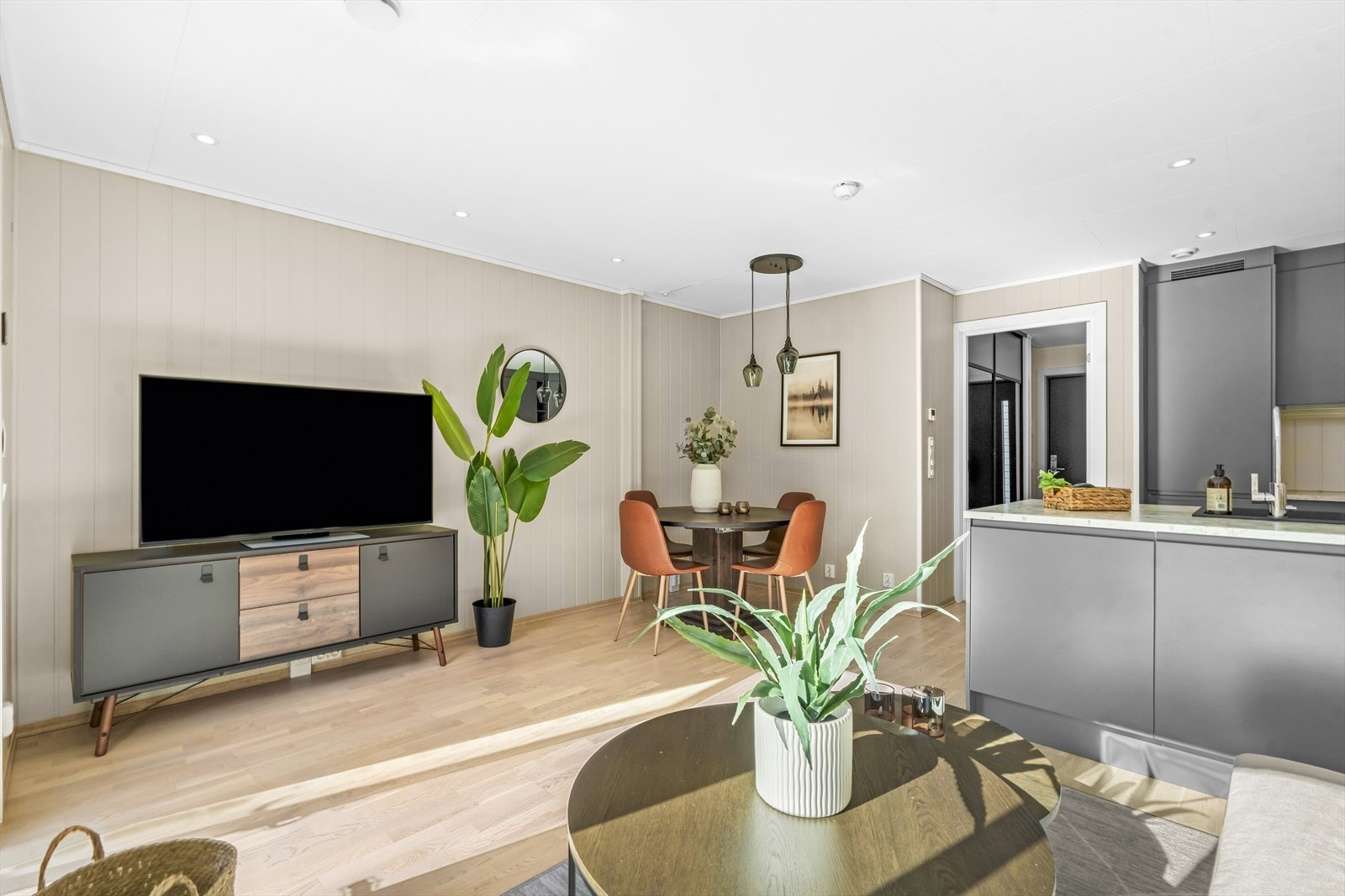 Stuen ligger i åpen løsning med kjøkkenet og fremstår som et lyst og luftig allrom. Galleribilde