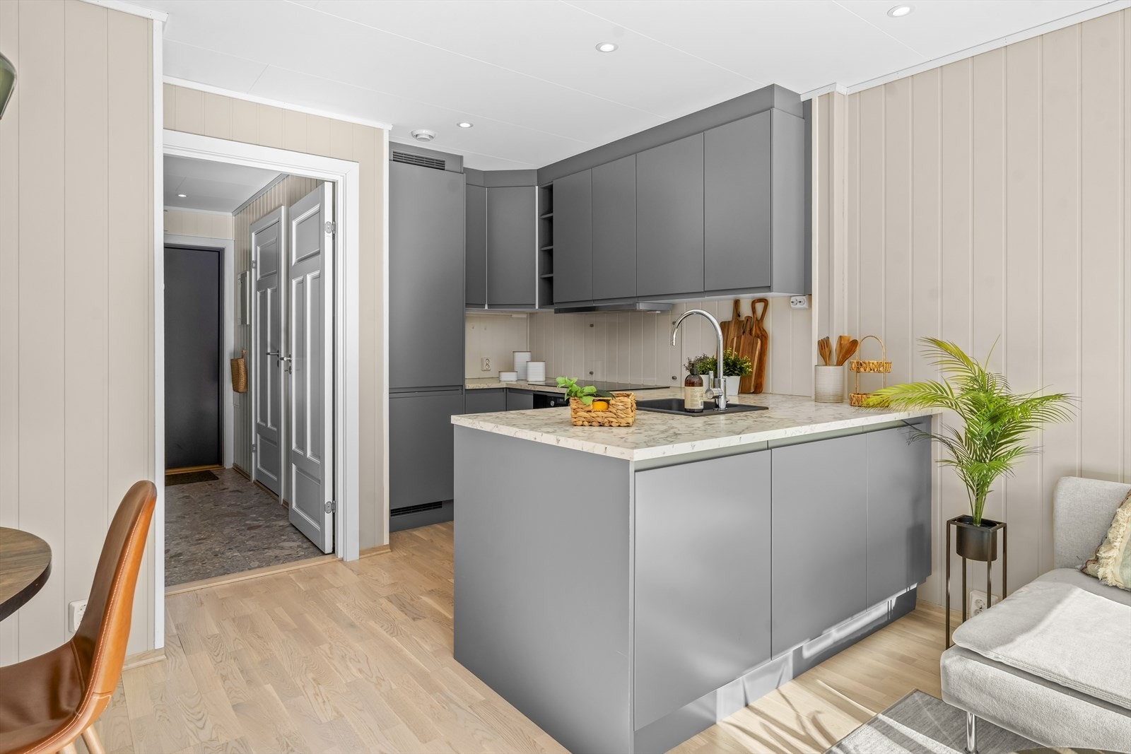 Boligen har et pent og moderne kjøkken fra byggeår, med innredning bestående av glatte, grå fronter og laminert benkeplate med marmordesign. Galleribilde