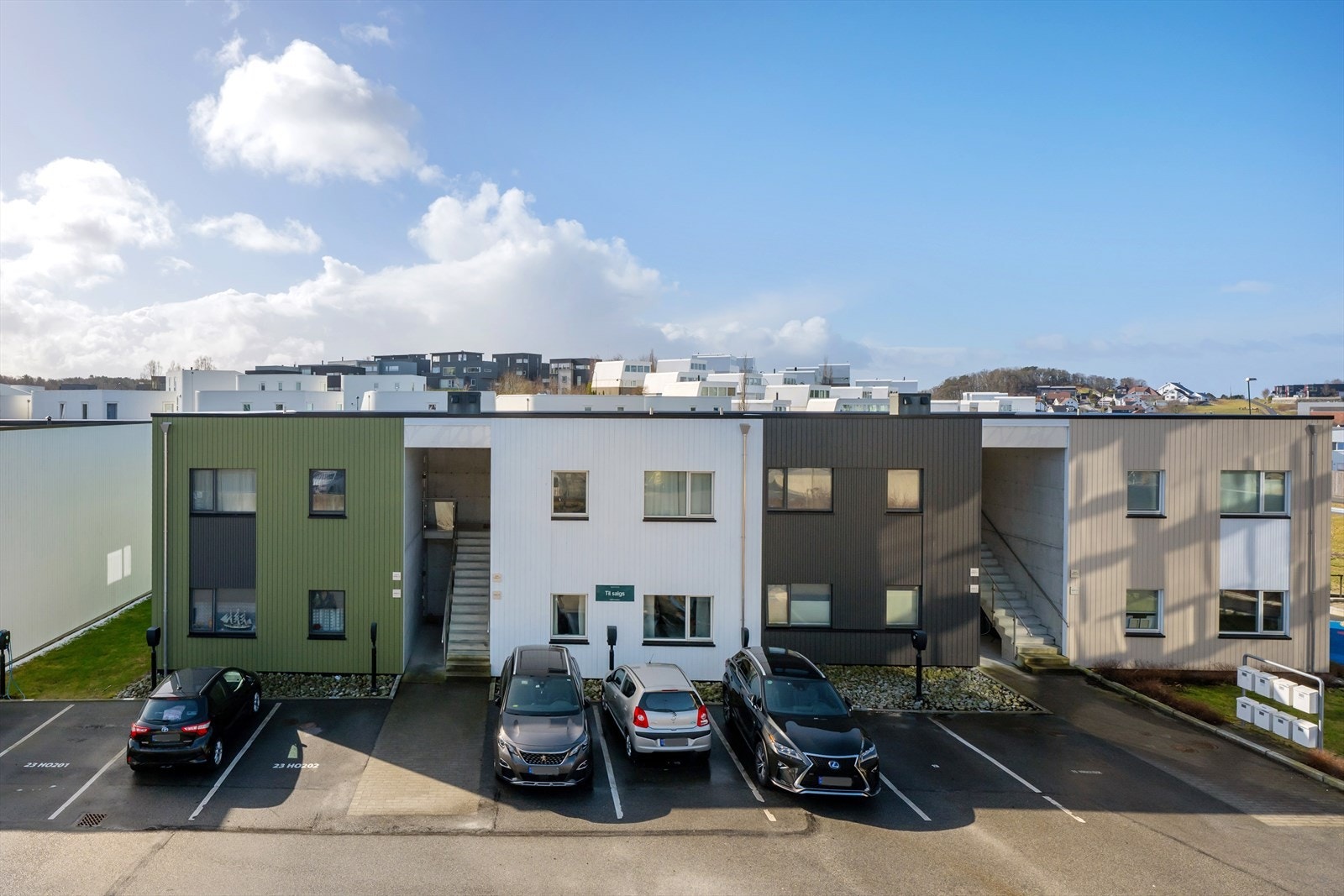 Parkering rett utenfor leiligheten, med stolpe klargjort for montering av elbillader. Galleribilde