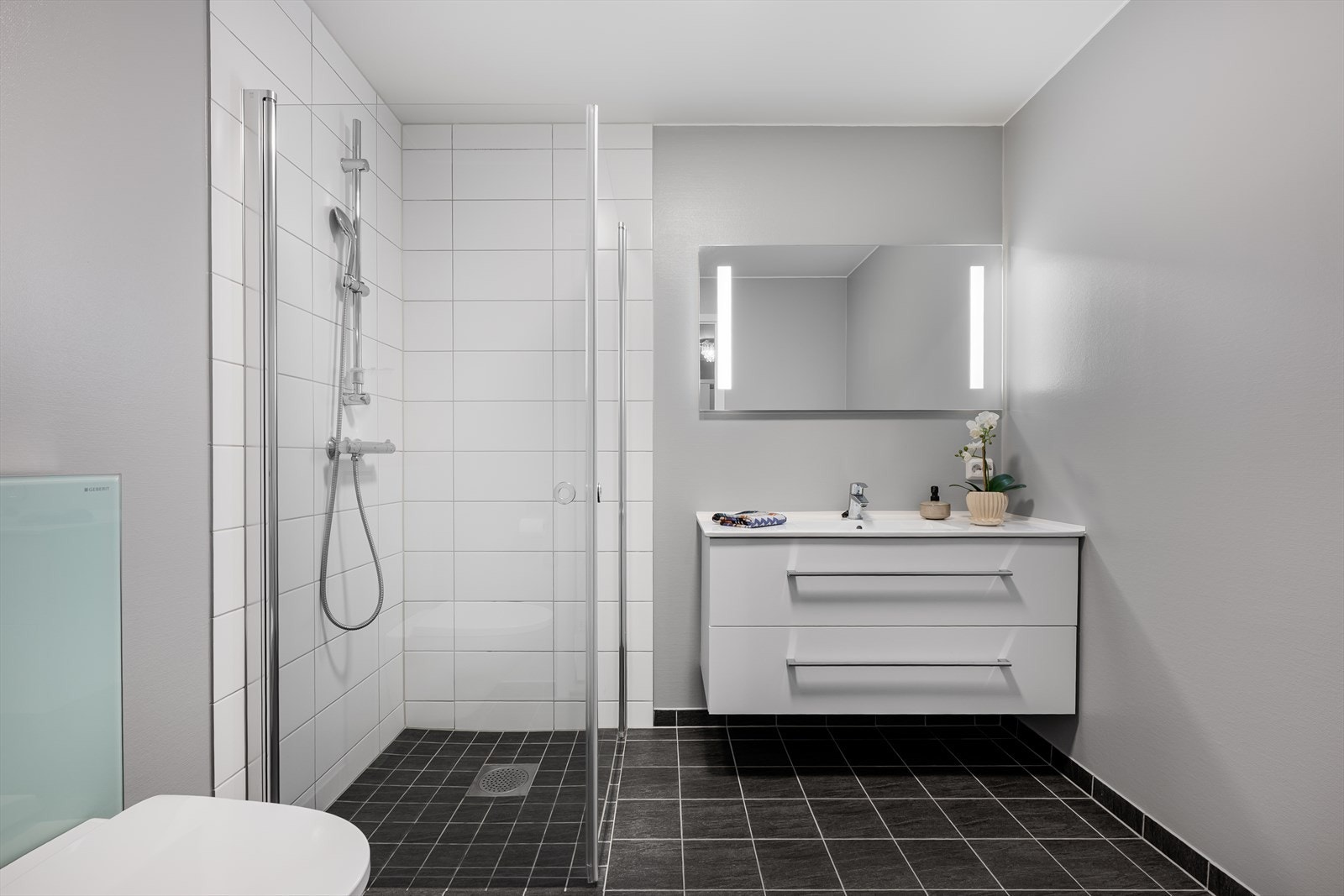 Delikat baderom med flislagt gulv og dusjsone. Galleribilde