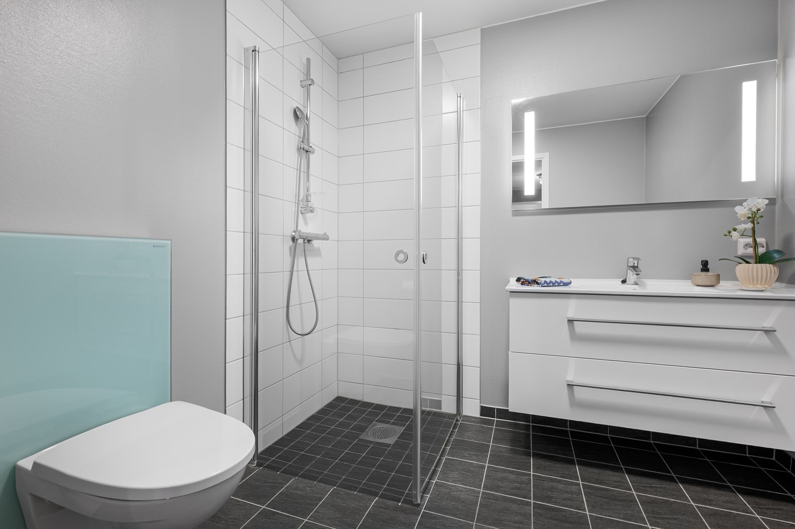 Nedfelt servantskap med skuffeseksjon og lyssatt speil. Galleribilde