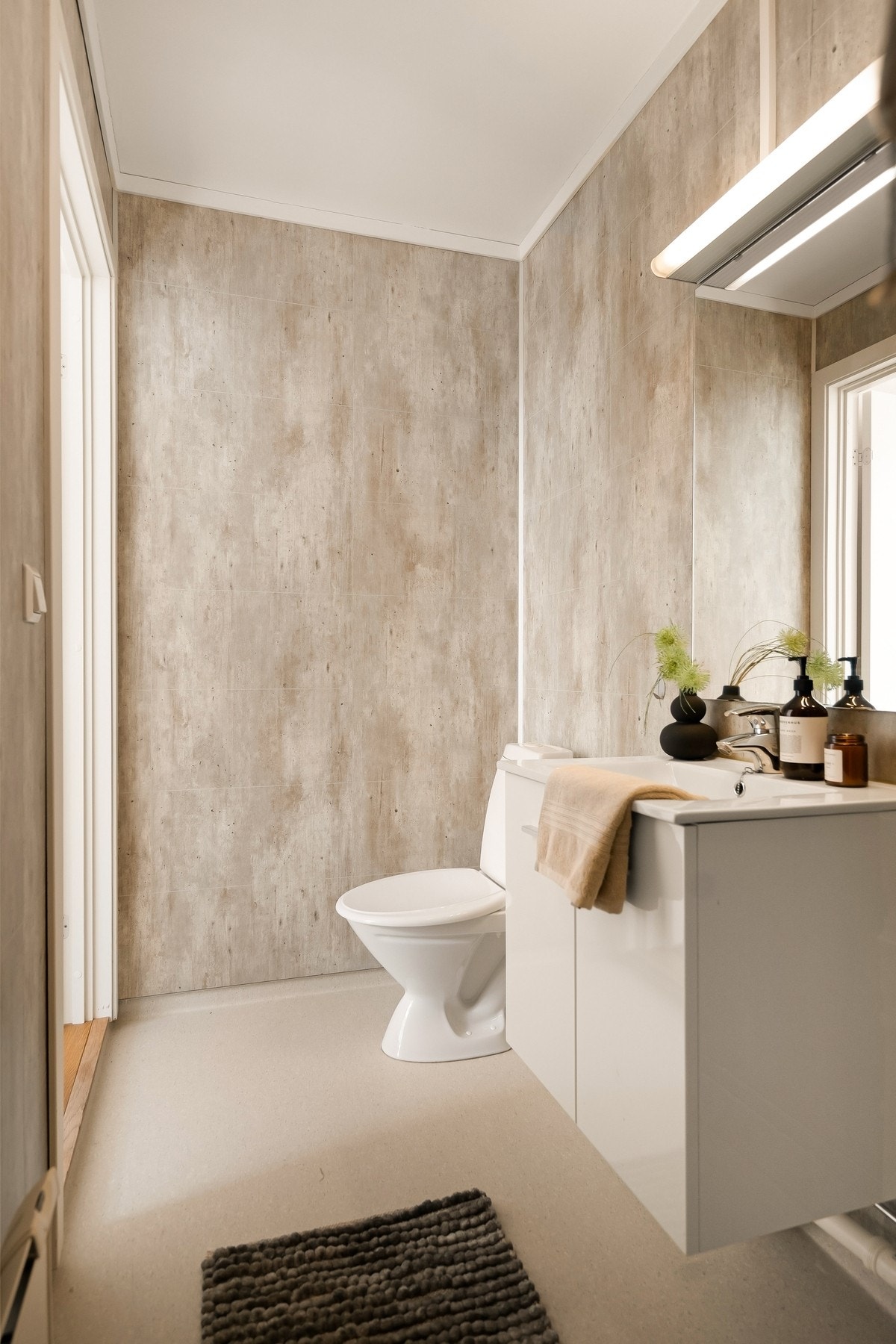 Belegg på gulv, baderomsplater på vegger, kabinett, innredning med vask, toalett og opplegg for vaskemaskin og tørketrommel Galleribilde