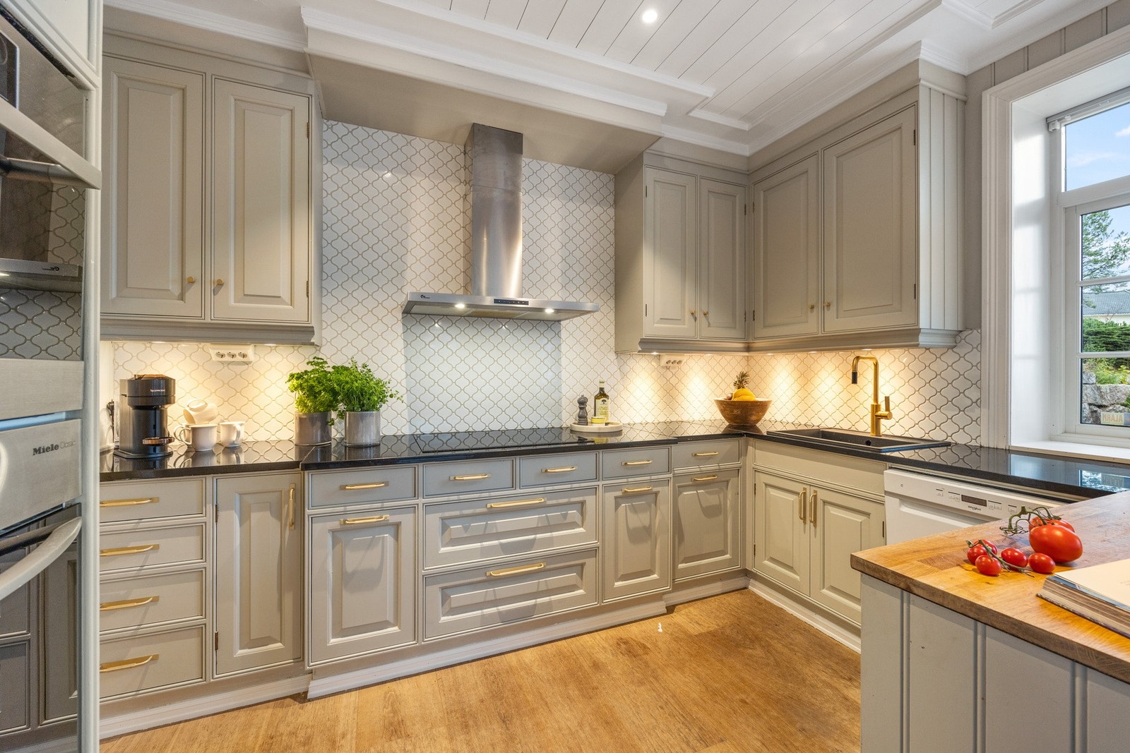 Kjøkkenet har profilerte fronter kombinert med granittbenkeplate som gir et klassisk og gjennomført uttrykk. Galleribilde