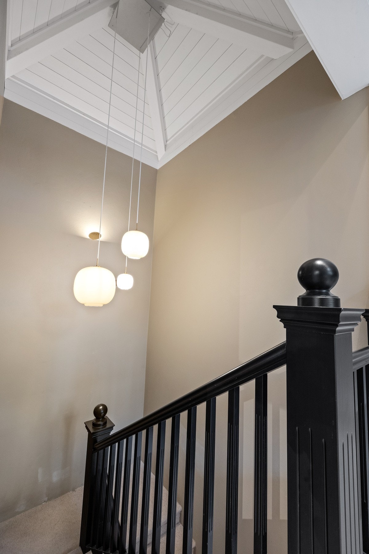 Elegant trappeløp opp til 2. etasje med sort rekkverk og generøs takhøyde. Galleribilde