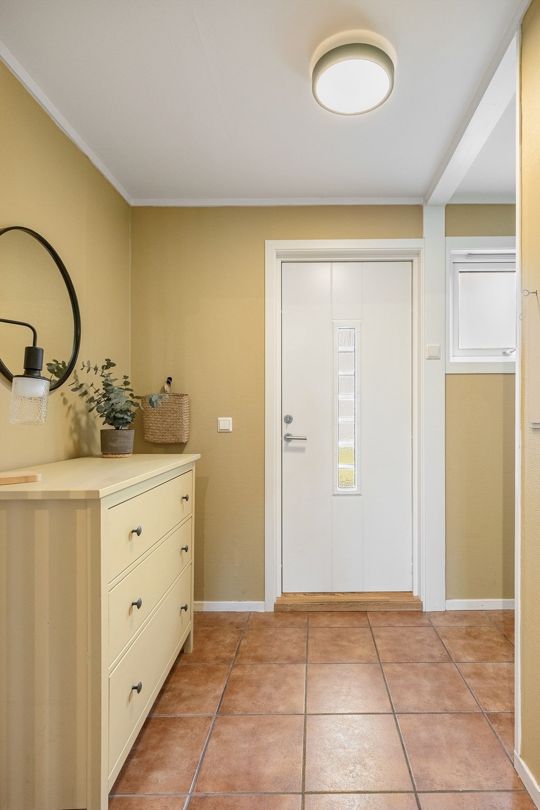 Entréen er innbydende med fliser på gulv. Rommet oppleves luftig og romslig og har lune farger på overflatene. Galleribilde