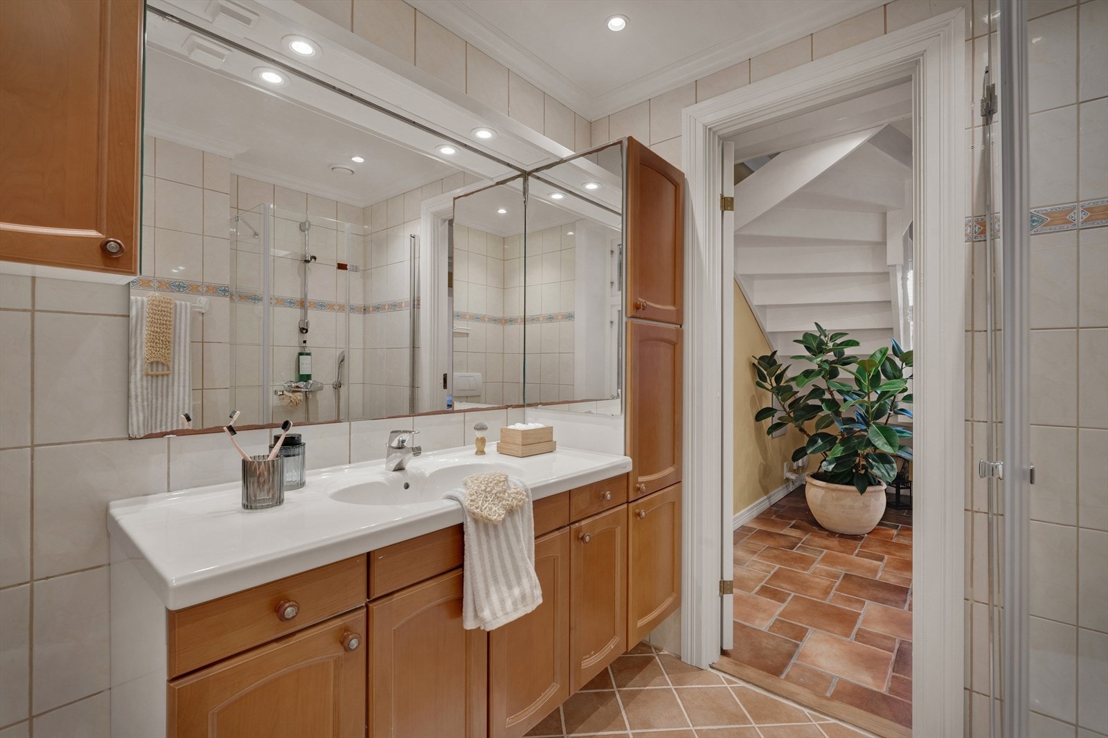 Innredningen består av vegghengt toalett, baderomsinnredning med nedfelt servant, speil med integrert belysning og et dusjhjørne med kabinett. Galleribilde