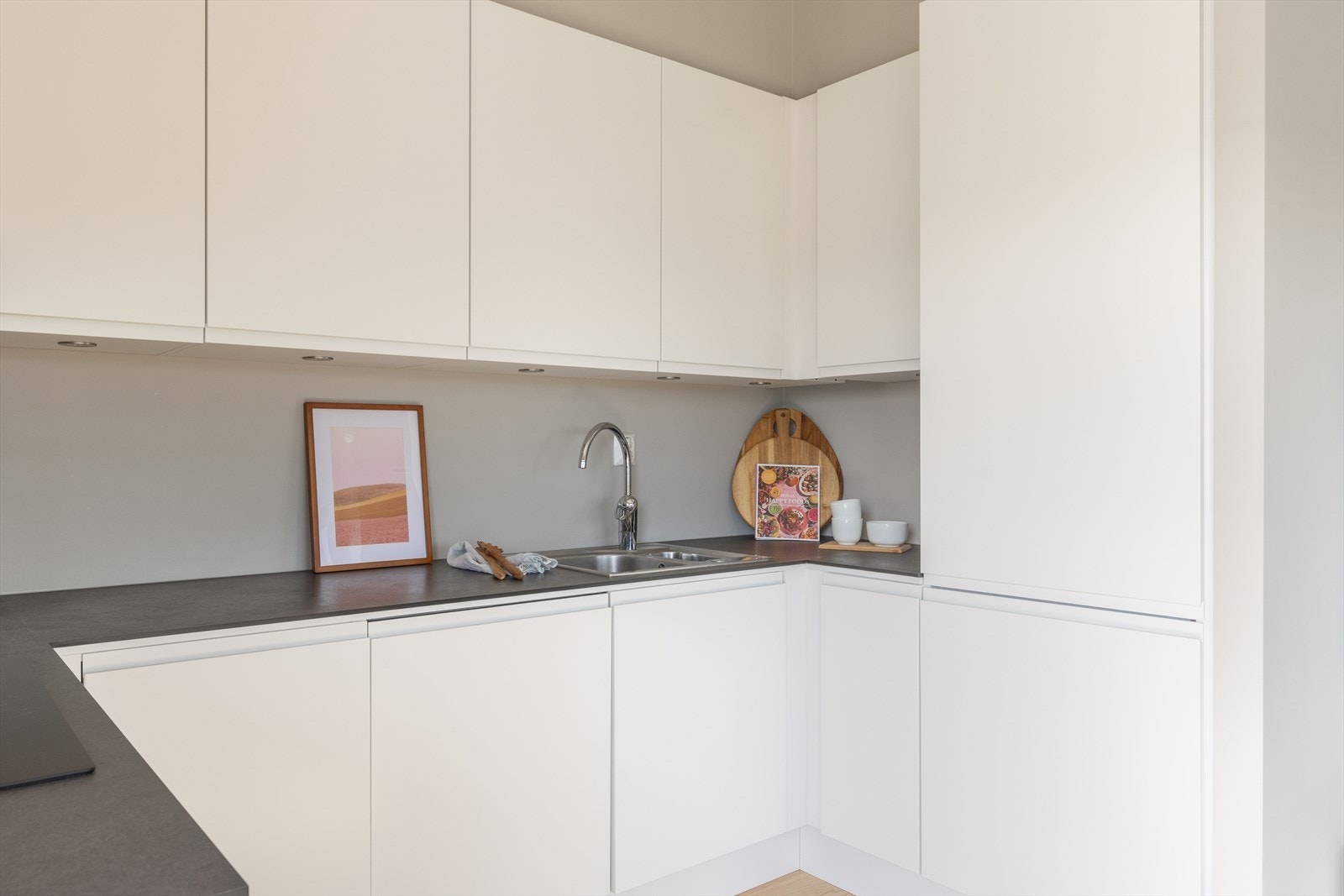 Kjøkkenet er innredet med stekeovn, induksjonstopp, oppvaskmaskin, kjøl-/fryseskap og ventilator. Galleribilde