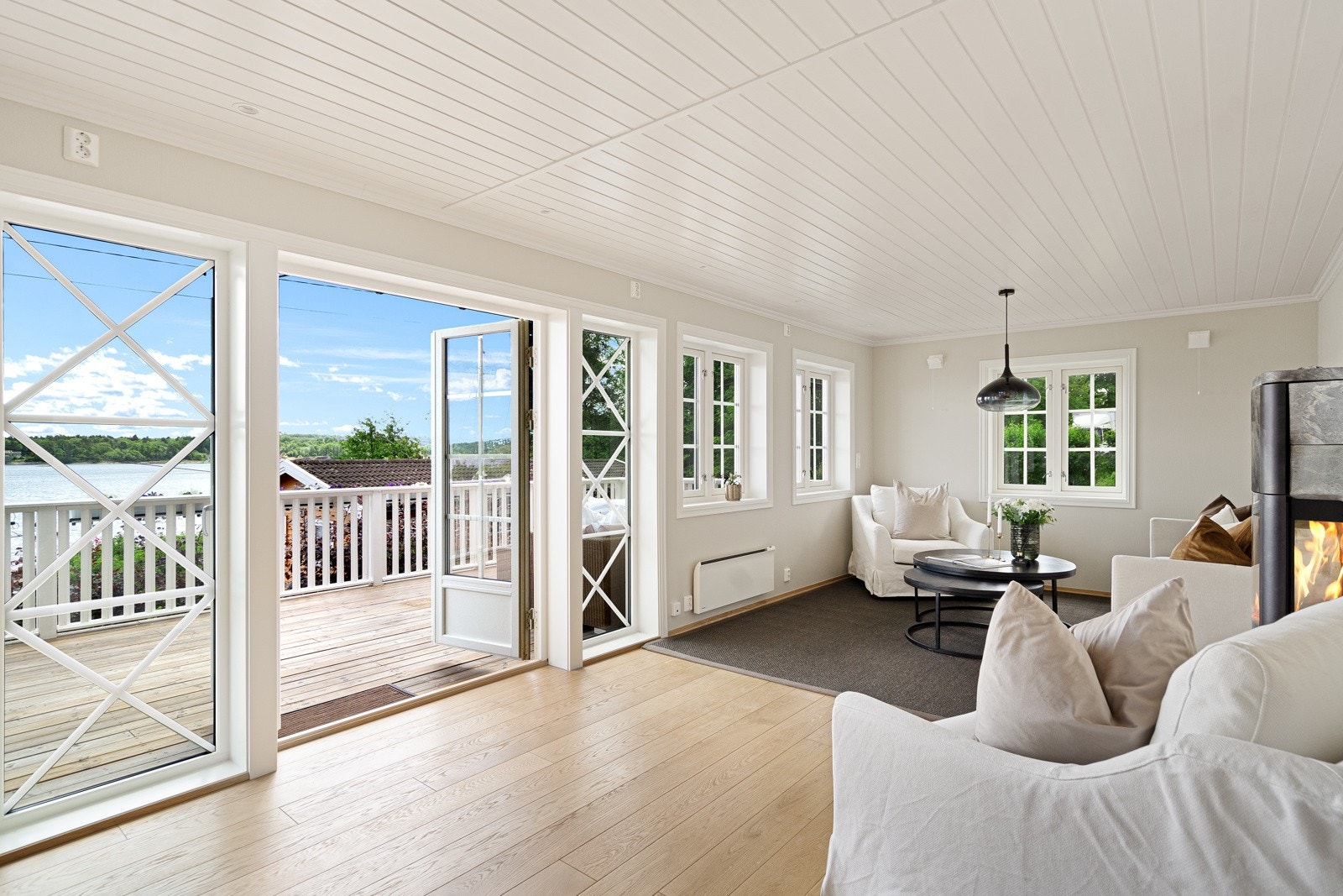 Delikat innredet stue med doble dører til stor sjø-orientert terrasse Galleribilde