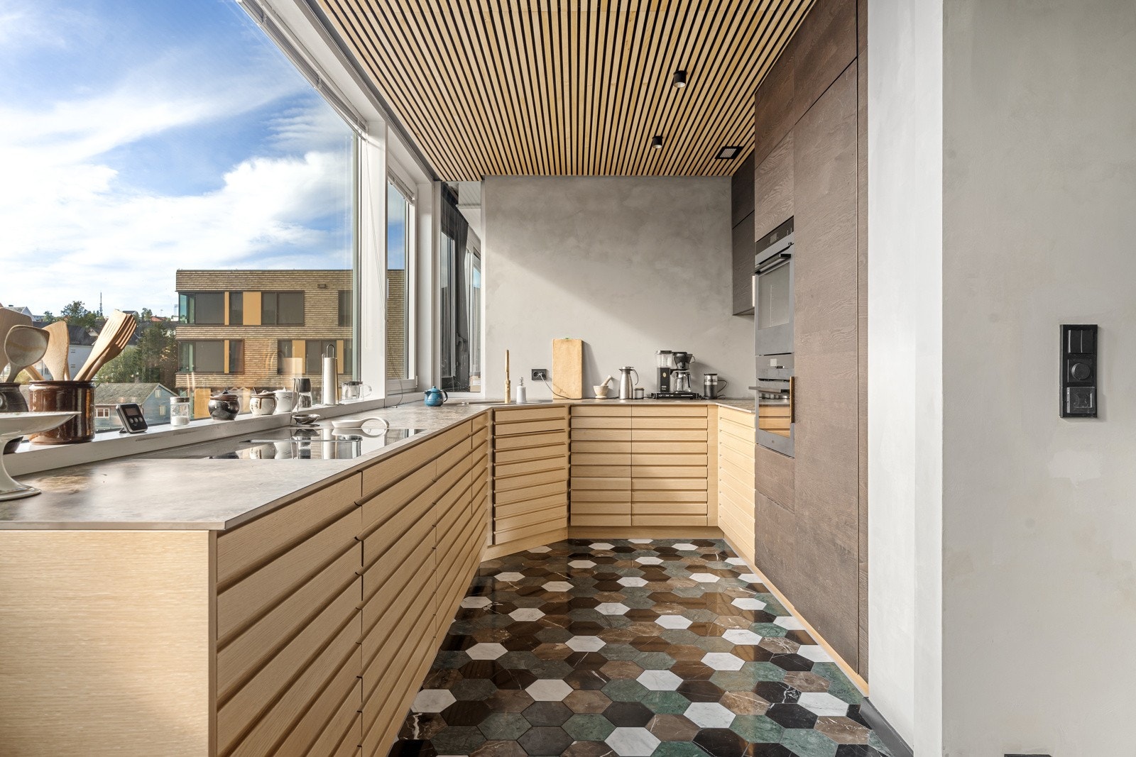 Moderne kjøkken med eikefronter og benkeplate av stein/kompositt. Galleribilde