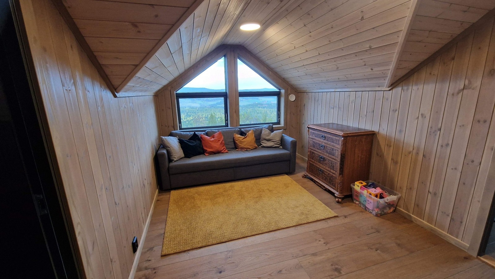 Loftstue er nå innredet som lekerom med sovesofa, men er også satt opp til å være TV-stue. Galleribilde