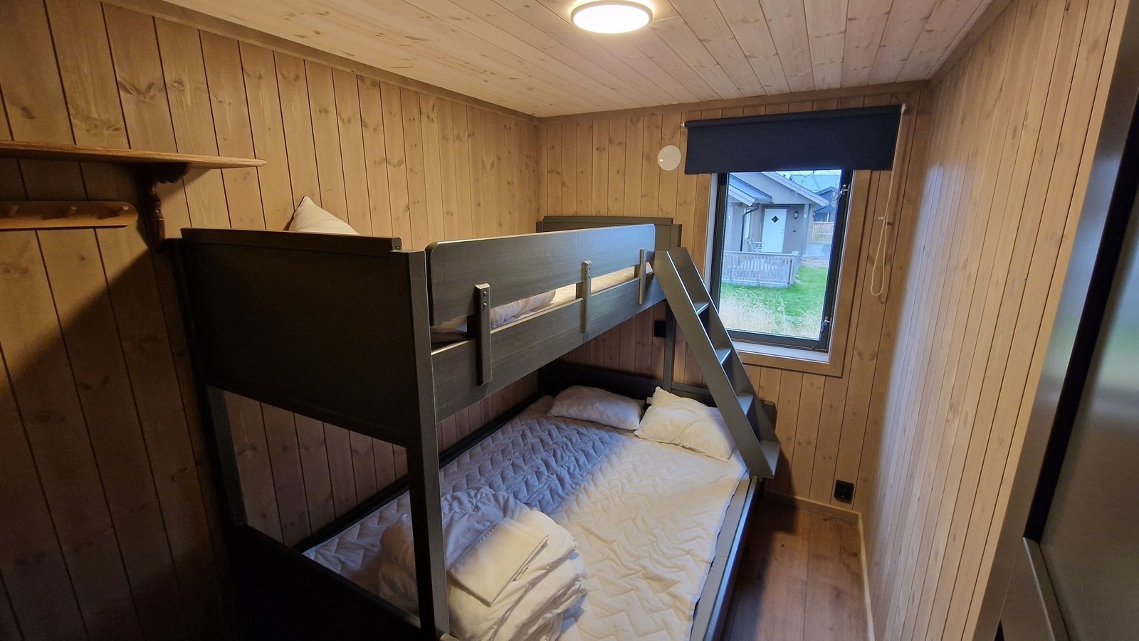 Minste soverom nede med 150/90x200 køyeseng som er plassbygd med samme farge som mange detaljer i hytta, slik som dører. Galleribilde