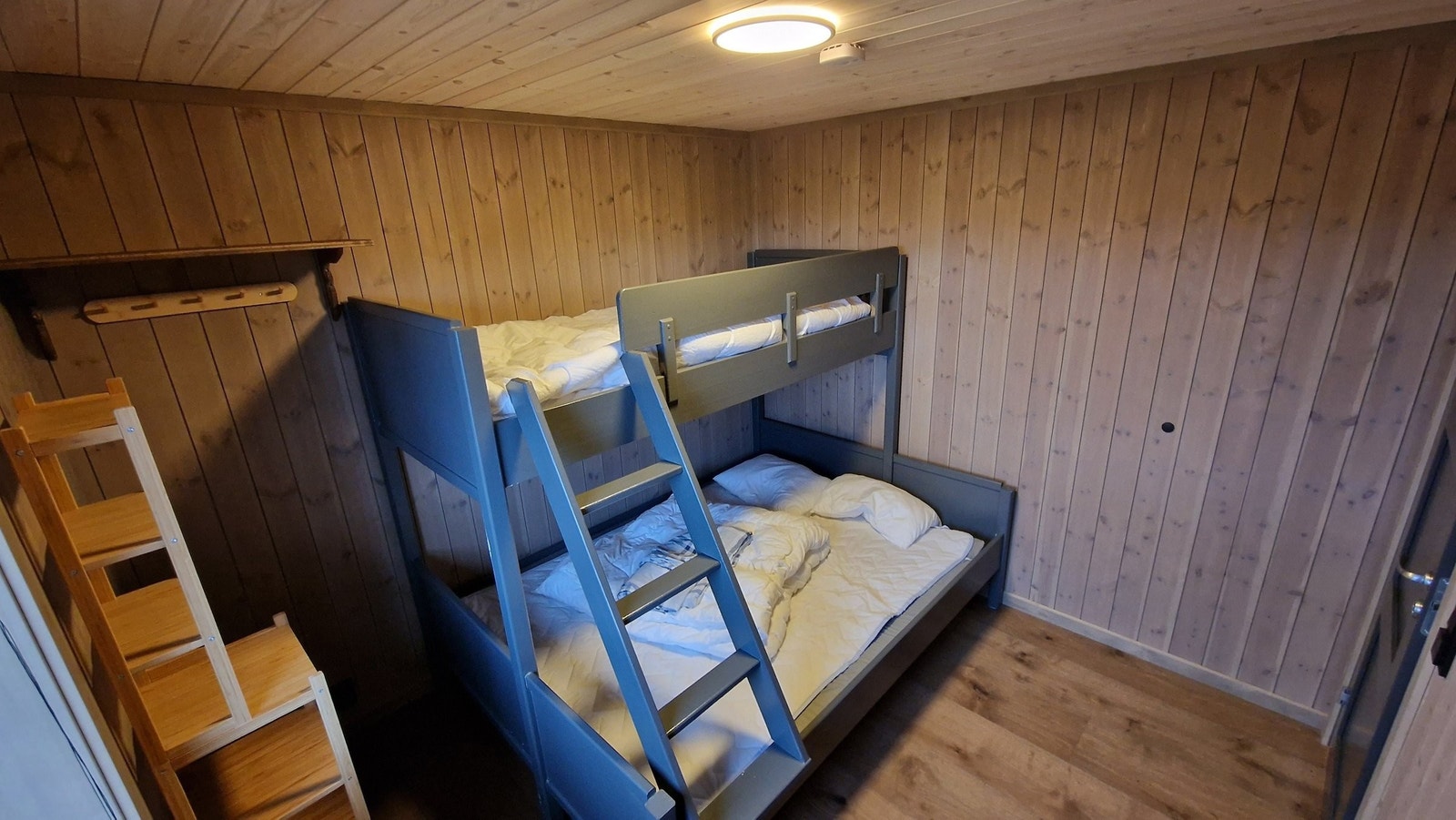 Største soverom nede med 150/90x200 køyeseng som er plassbygd med samme farge som mange detaljer i hytta. Galleribilde