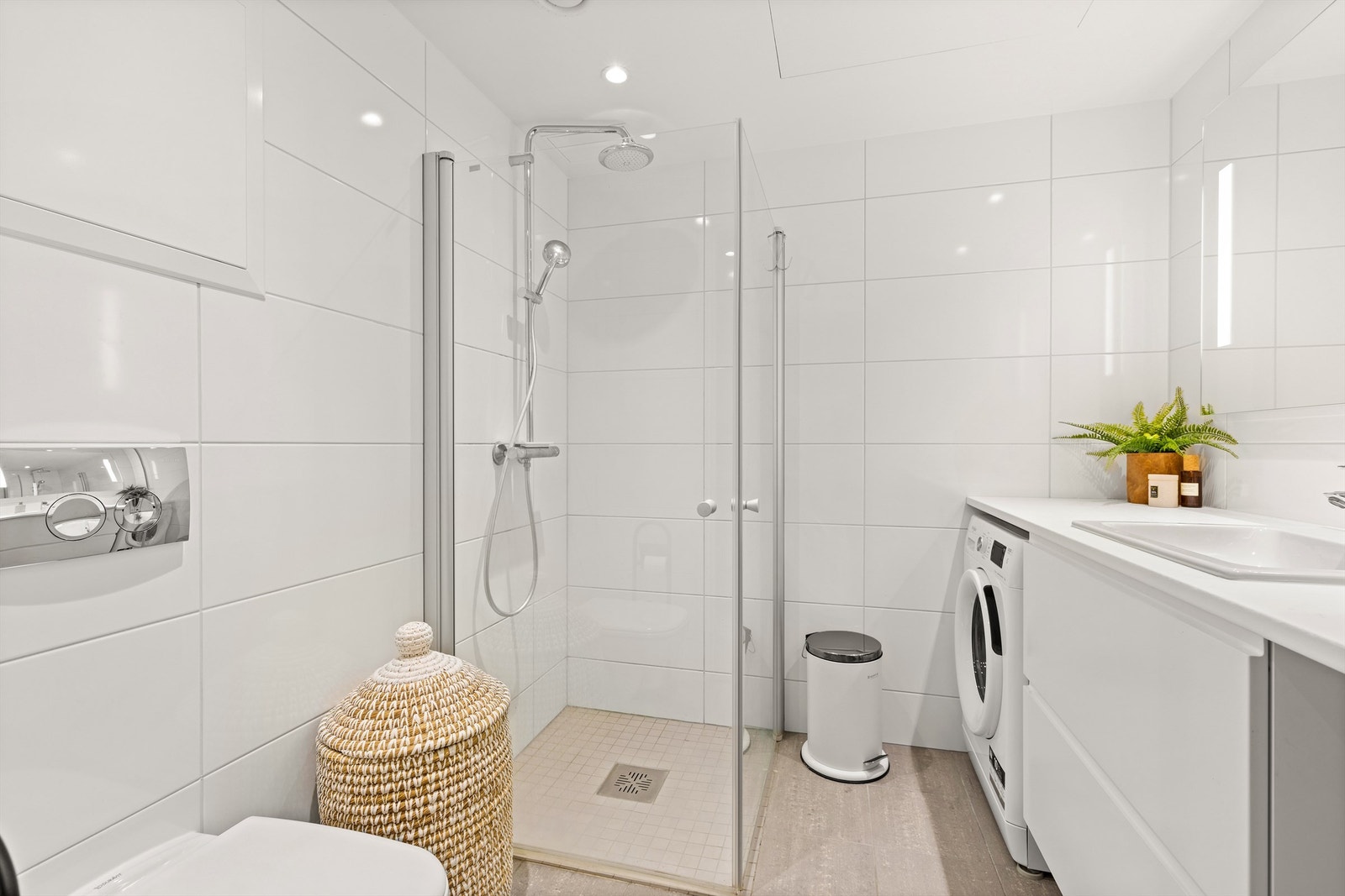 Badet er utstyrt med vegghengt toalett og dusjhjørne med innfellbare glassdører som frigjør gulvplass. Galleribilde