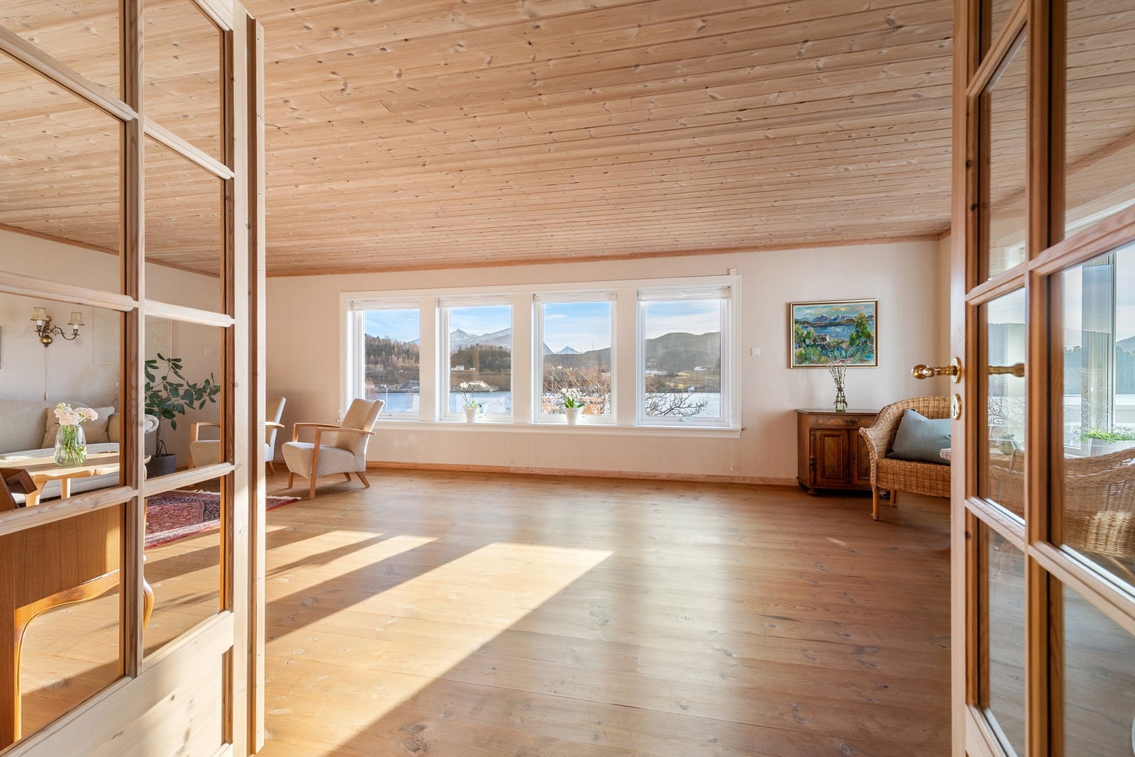 Stue med store vindusflater mot syd med flott utsikt mot fjord og fjell Galleribilde
